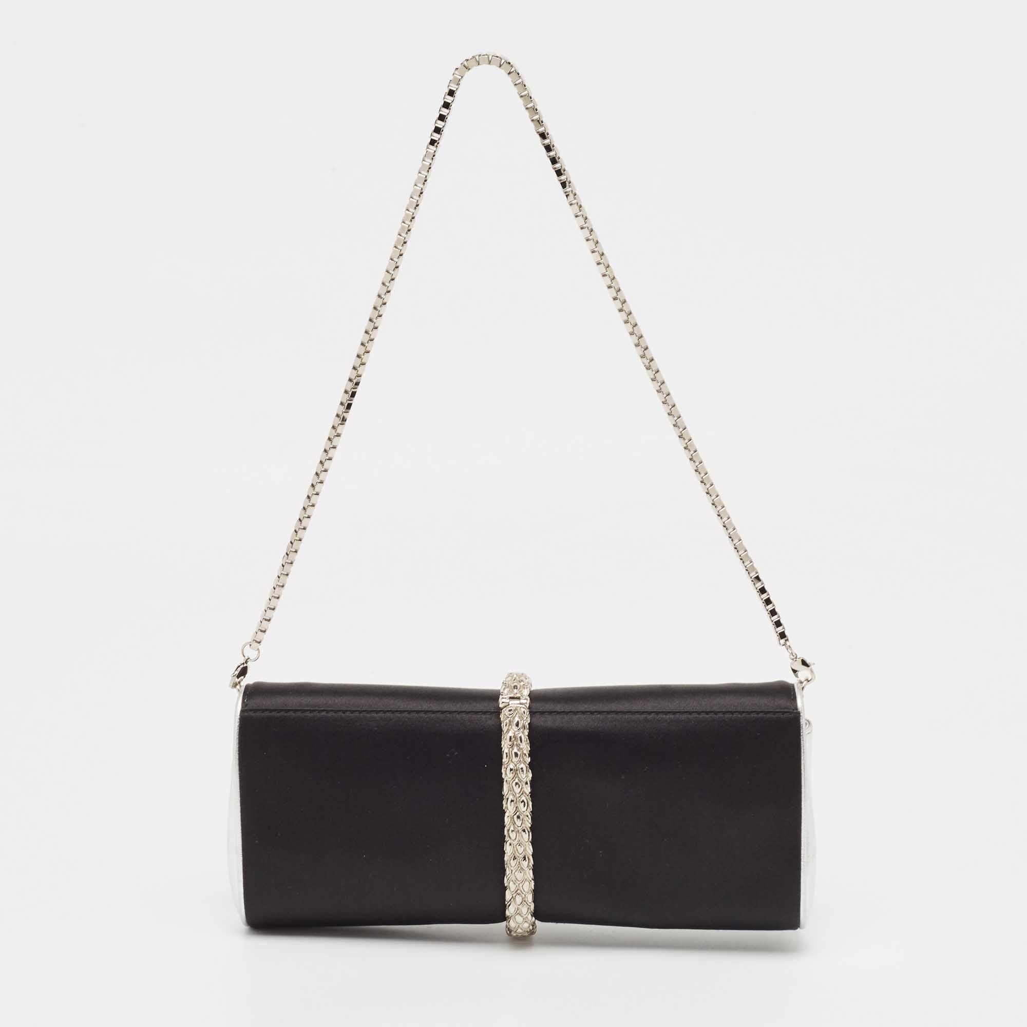 This clutch from Roberto Cavalli has an appealing design, perfect to complement an evening dress or a party ensemble. Crafted from satin and leather, the creation has a crystal-embellished snake motif on the front, a well-lined interior, and a chain