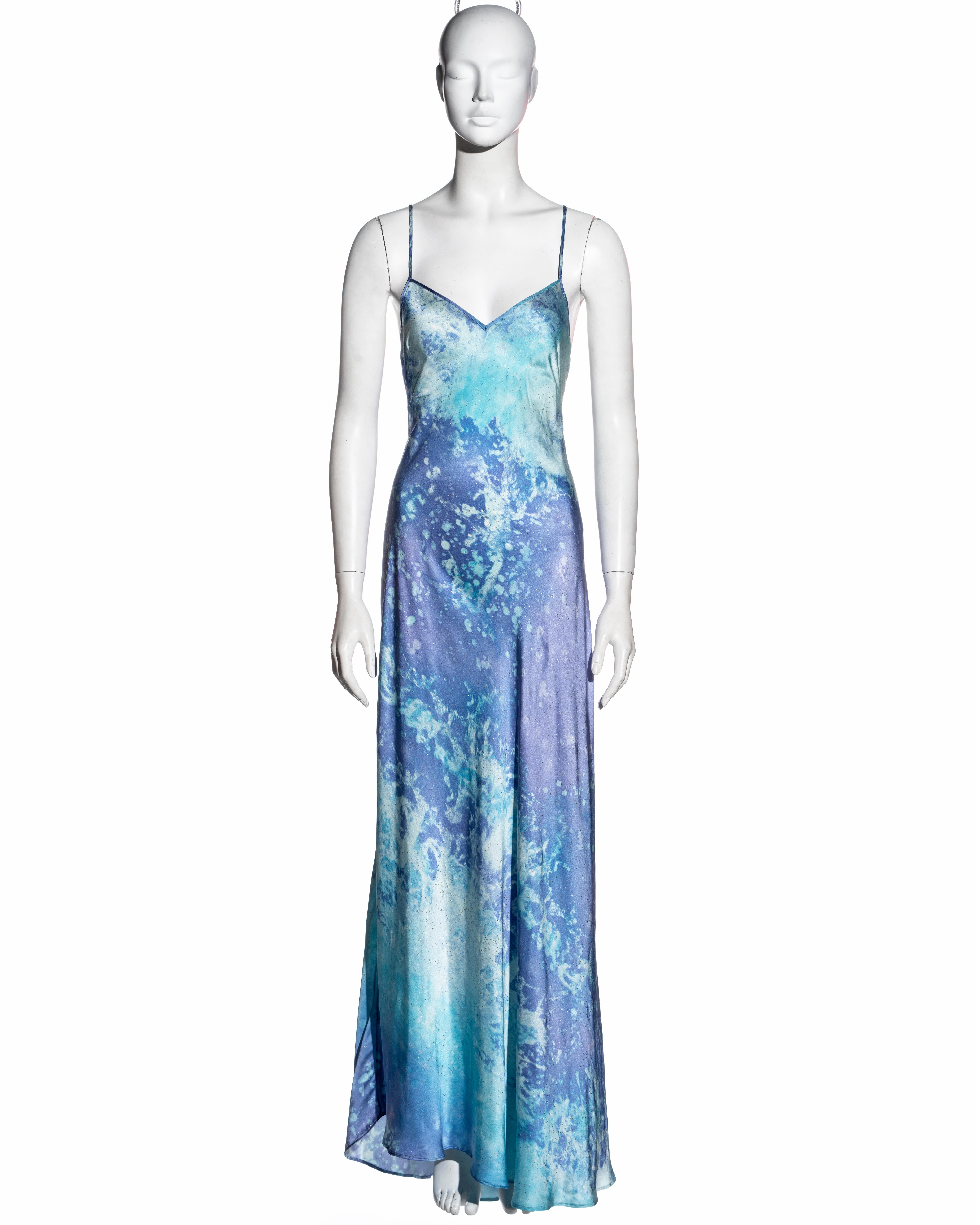 ▪ Roberto Cavalli blue and purple silk maxi dress 
▪ Acid wash print with gold glitter  
▪ Open back with drape
▪ V neck 
▪ Long ties with crystal charms criss-cross at back
▪ Asymmetric hemline
▪ Size Medium 
▪ Spring-Summer 1999 
▪ 100% Silk
▪