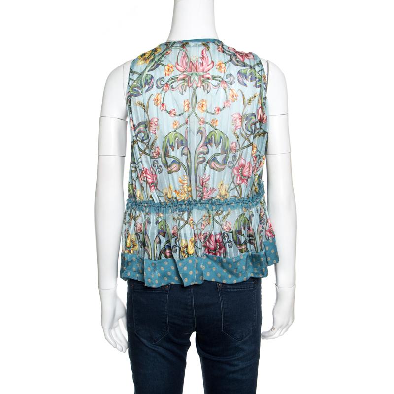 You'll amaze the crowds when you step out in this fabulous blue blouse from Roberto Cavalli. It is made of 100% silk and features a beautiful floral printed pattern all over it. It flaunts a round neckline and a ruffled feather tie-up detailing on