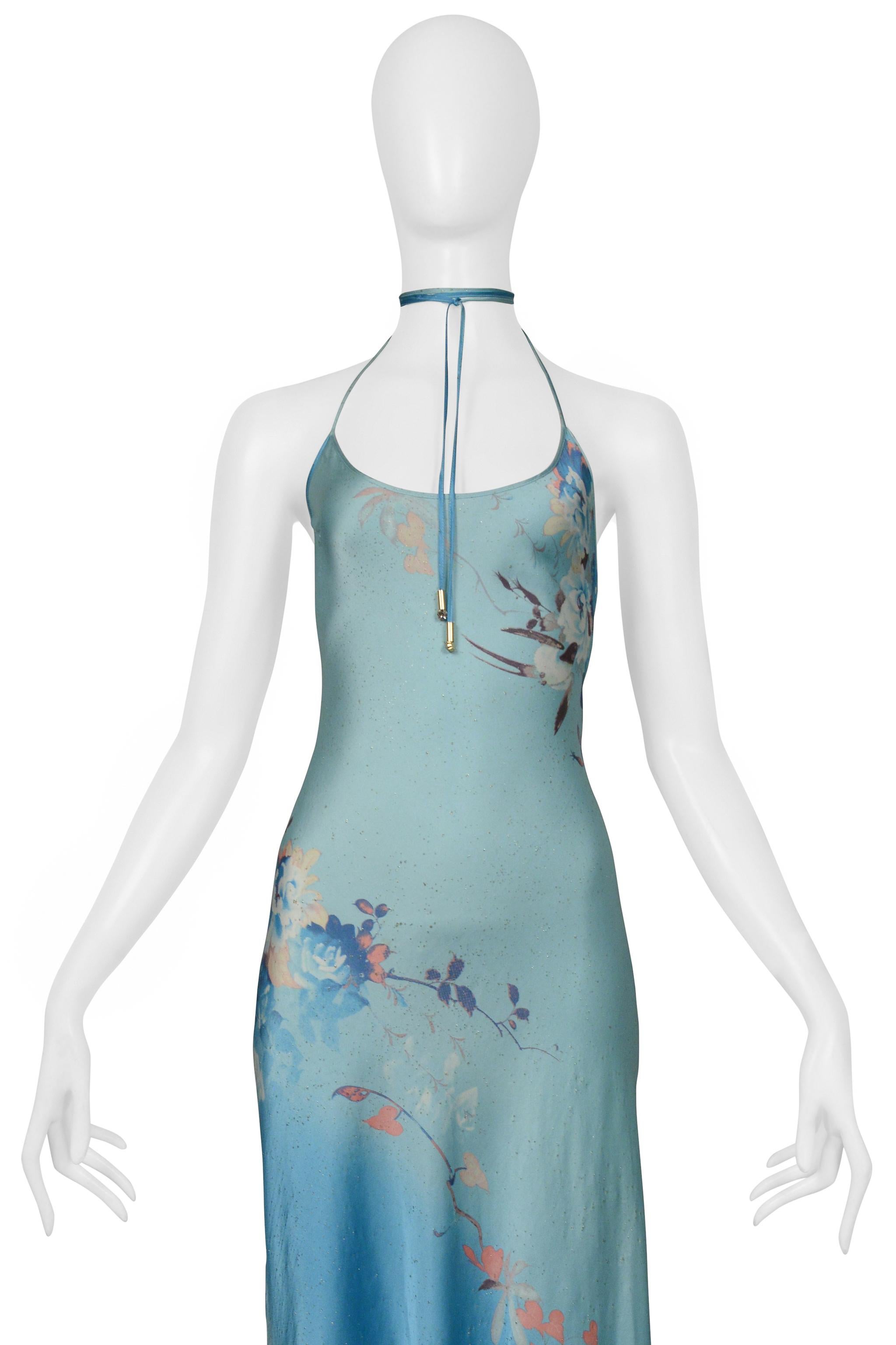 Resurrection Vintage is thrilled to present an exclusive vintage Roberto Cavalli blue slip dress. This exquisite piece showcases a decorative floral pattern with gold metallic flecks, and boasts an exposed back, tie closure with gold beads and clear