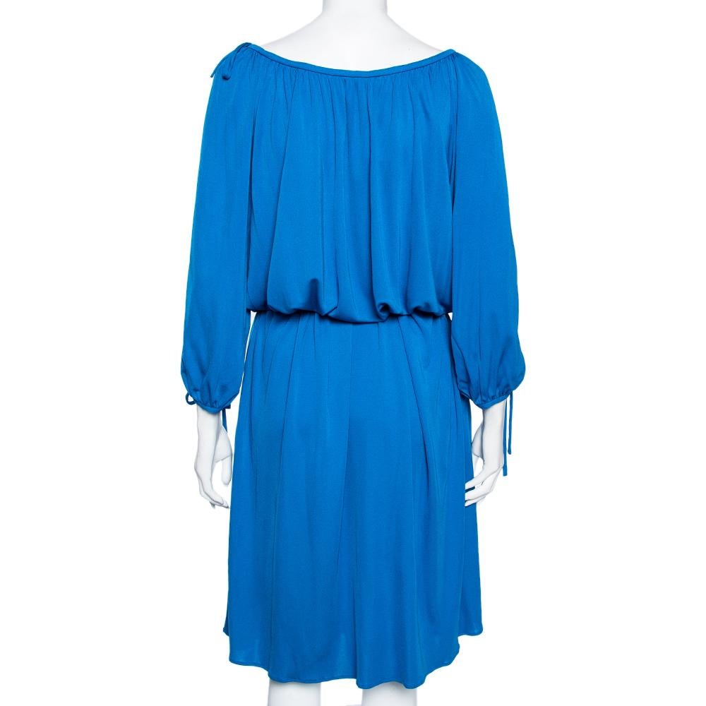 Tragen Sie dieses Kleid von Roberto Cavalli und verbringen Sie den ganzen Tag mit Stil. Dieses Kleid mit Gürtel wurde aus blauem Jersey-Material gefertigt und verfügt über Ärmel mit kalten Schultern und Quasten zum Binden. Außerdem ist sie mit zwei
