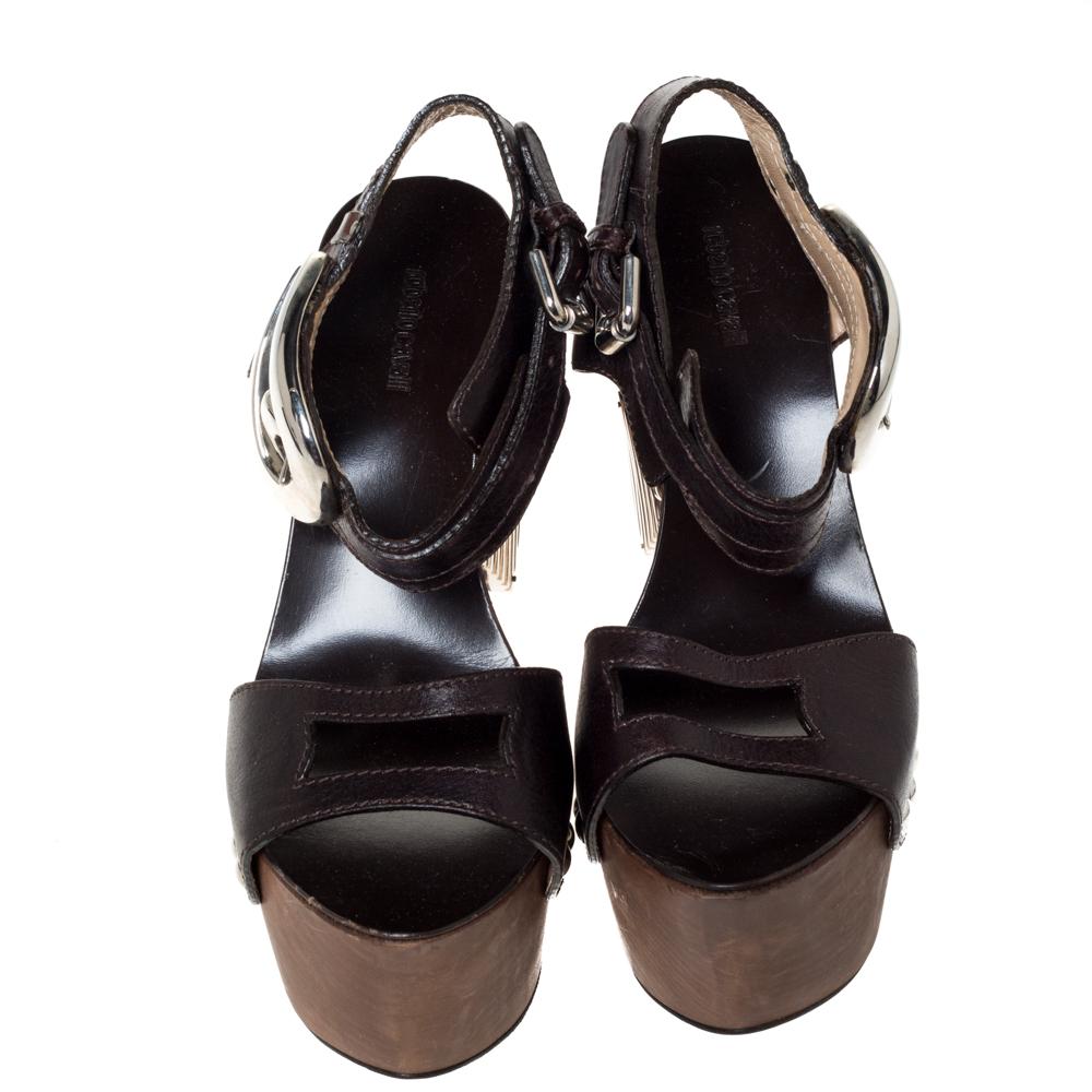 Make a statement by sporting these stylish sandals by Roberto Cavalli. Crafted from quality leather, they come in a versatile shade of brown. They have open toes, high platforms, 14.5 cm wedge heels, stud & buckle detailing, ankle strap and