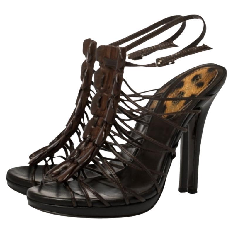 Accentuate your feet in the most elegant way when you wear these sandals by Roberto Cavalli. Made from leather in a brown hue, they feature a strappy design with peep toes and ankle buckle fastenings. Elevated on 12 cm heels, the sandals will look