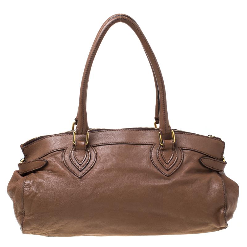 This brown satchel is ingeniously crafted from leather. It is Italian-made and features dual handles, gold-tone hardware and protective metal feet. It opens to a fabric-lined interior. Spacious enough for all your essentials, this Roberto Cavalli