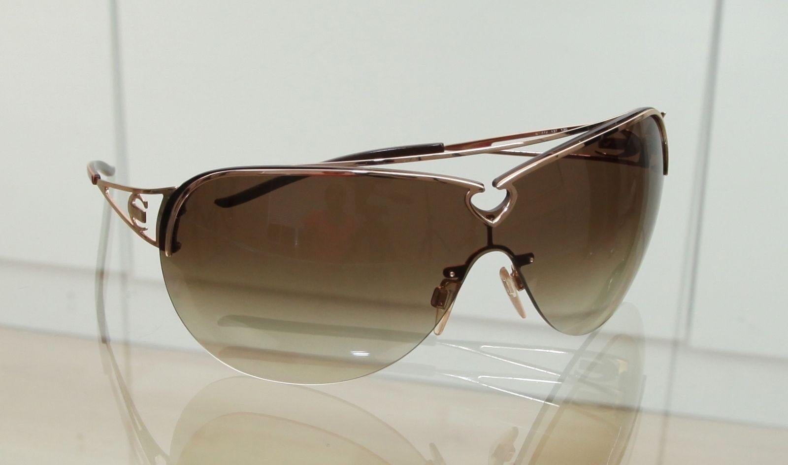 ROBERTO CAVALLI BROWN GRADIENT SHIELD SUNGLASSES

Lens: Brown

Details: 
 - Gold Frame with front cut out heart shape design
 - Gold-tone metal arms
 - Cavalli logo at corners
 - Comes with Roberto Cavalli sunglass case

Condition: Gently worn.  No