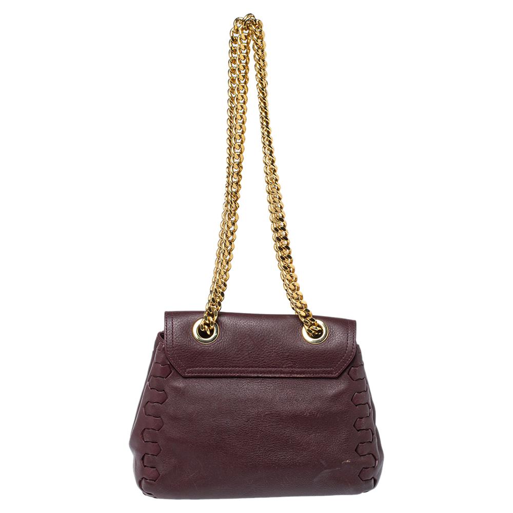 This stunning burgundy bag is by Roberto Cavalli. Crafted from leather, it comes with a spacious fabric-lined interior that will hold all your daily essentials. It features dual chain-link handles and interesting details on both sides. Swing it