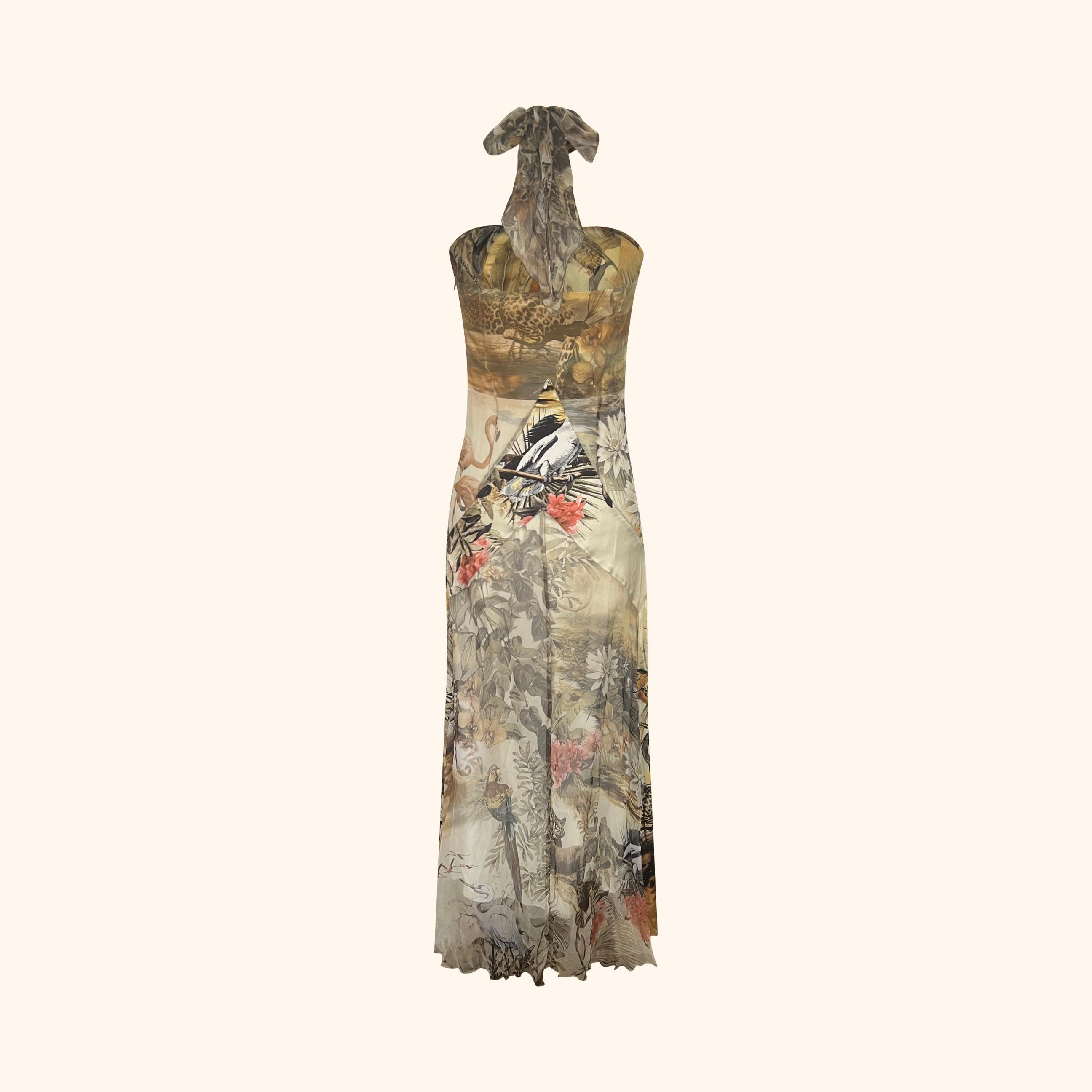Realizzato in una combinazione di seta liscia e chiffon semitrasparente, questo abito presenta la tipica stampa Jungling di Cavalli con uccelli esotici e flora nei toni della terra.
La scollatura a farfalla è impreziosita da una catena dorata e da