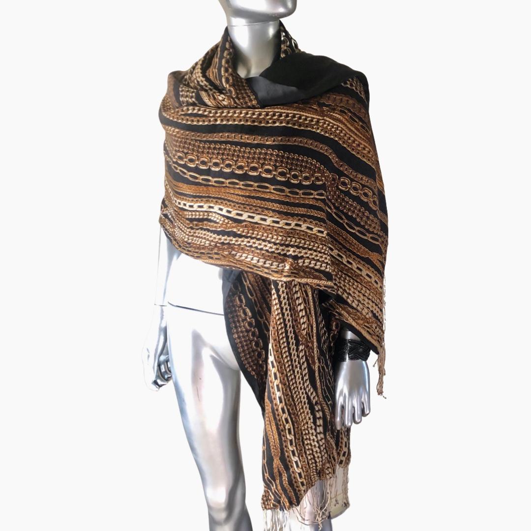 Such a chic wrap by Italian designer, Roberto Cavalli. Can be used as a scarf or a shawl... it's that big! the print is a super shic Cavalli signature brint of multi gold chains on a black lightweight wool ground. The other side is a high quality