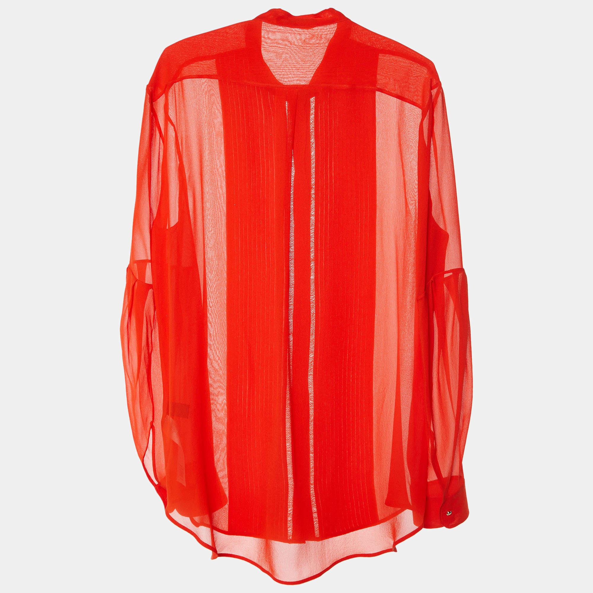 La camisa Roberto Cavalli es una pieza lujosa y elegante. Confeccionada en seda de vibrante color rojo coral, presenta delicados detalles de pestañas que añaden textura y sofisticación. El diseño de botones delanteros ofrece versatilidad y un estilo