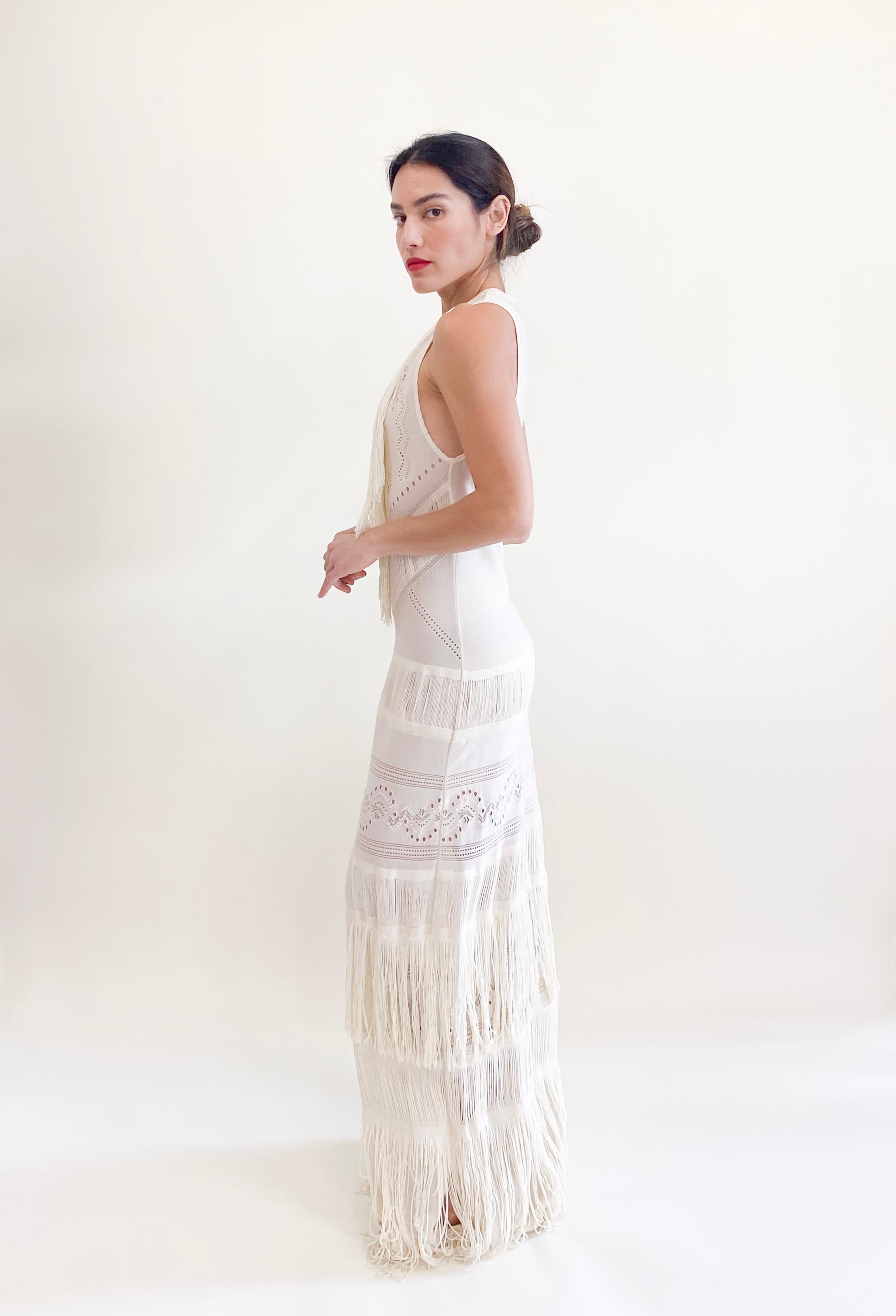 Elevate your style with the 2018/19 Roberto Cavalli White Knit Fringe Dress! This stunning dress features a flattering stretchy fabric, perfect for any occasion from bridal events to vacations. The beautiful cream color and intricate fringe