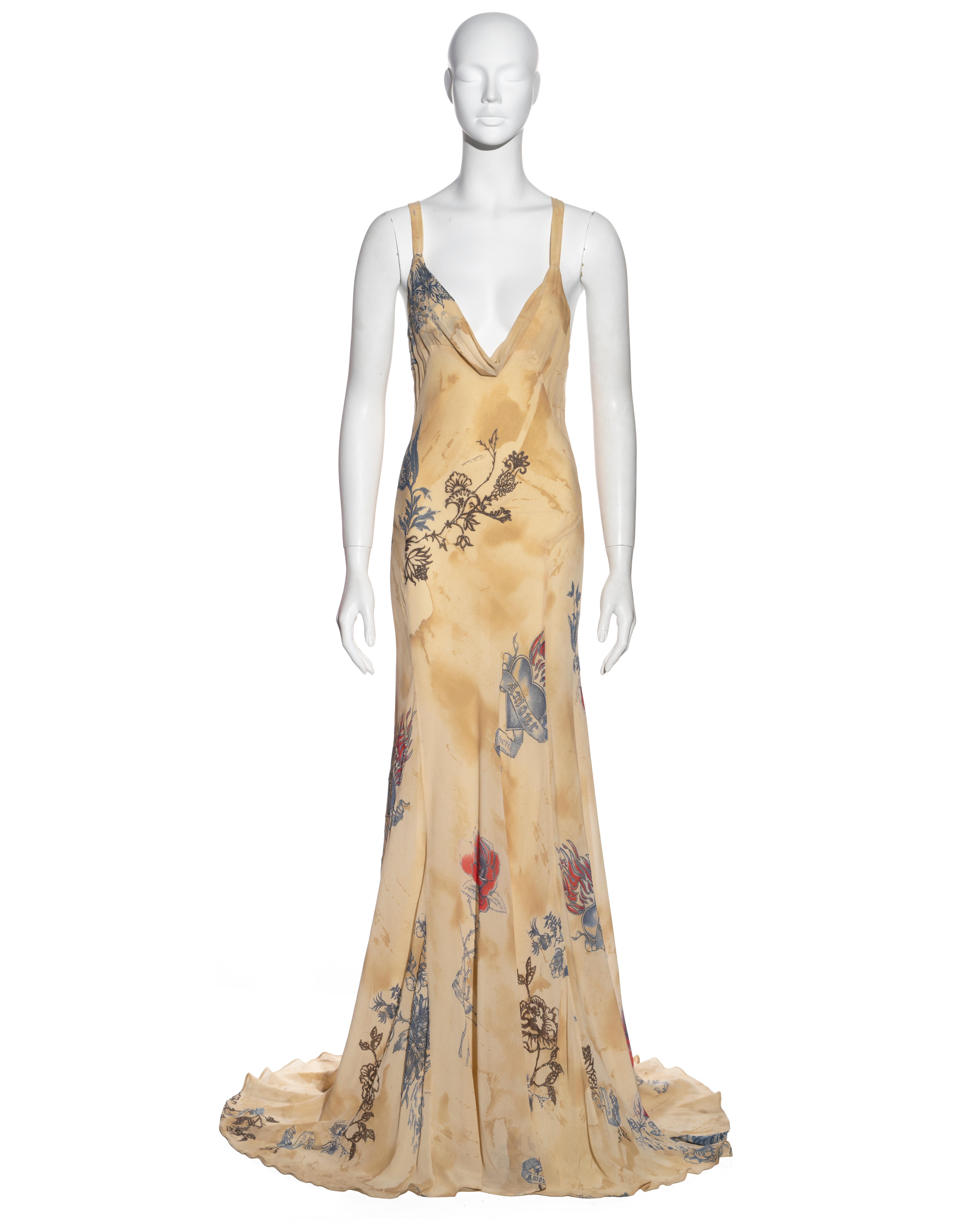 ▪ Roberto Cavalli evening dress  
▪ Sold by One of a Kind Archive
▪ Constructed from cream bias-cut silk
▪ Tattoo-style imagery of flowers, hearts and tigers
▪ Deep cowl neck 
▪ Open back 
▪ Floor-length skirt with train 
▪ Size Small
▪