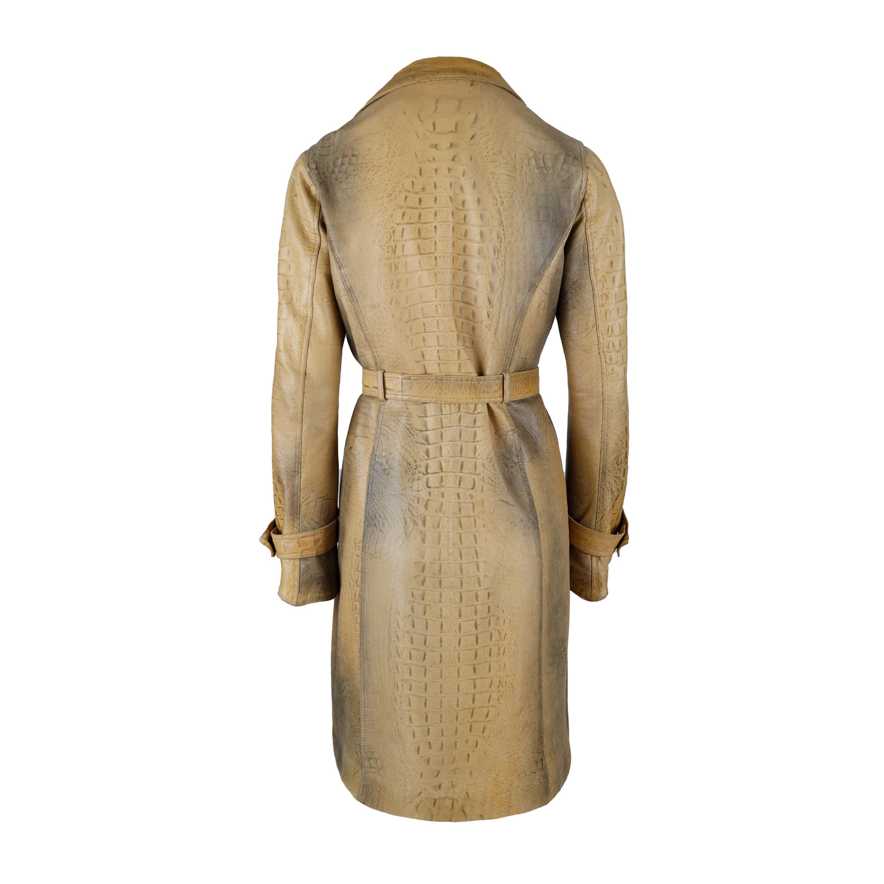 This Roberto Cavalli leather trench coat from Fall Winter 2000 collection is beautifully crafted from croc-embossed yellow-toned tan leather and finished with an ombre effect. It features a notched lapel collar, a belted construction, velcro cuff