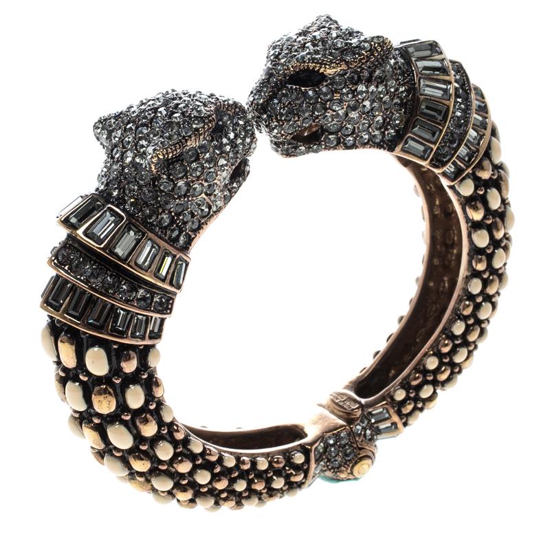 Beautifully sculpted from gold-tone metal, this Roberto Cavalli bangle is a choice of a modern woman. It carries an intricate design of studs and two panther heads embellished with crystals. This bracelet is classy and will be a fine outfit