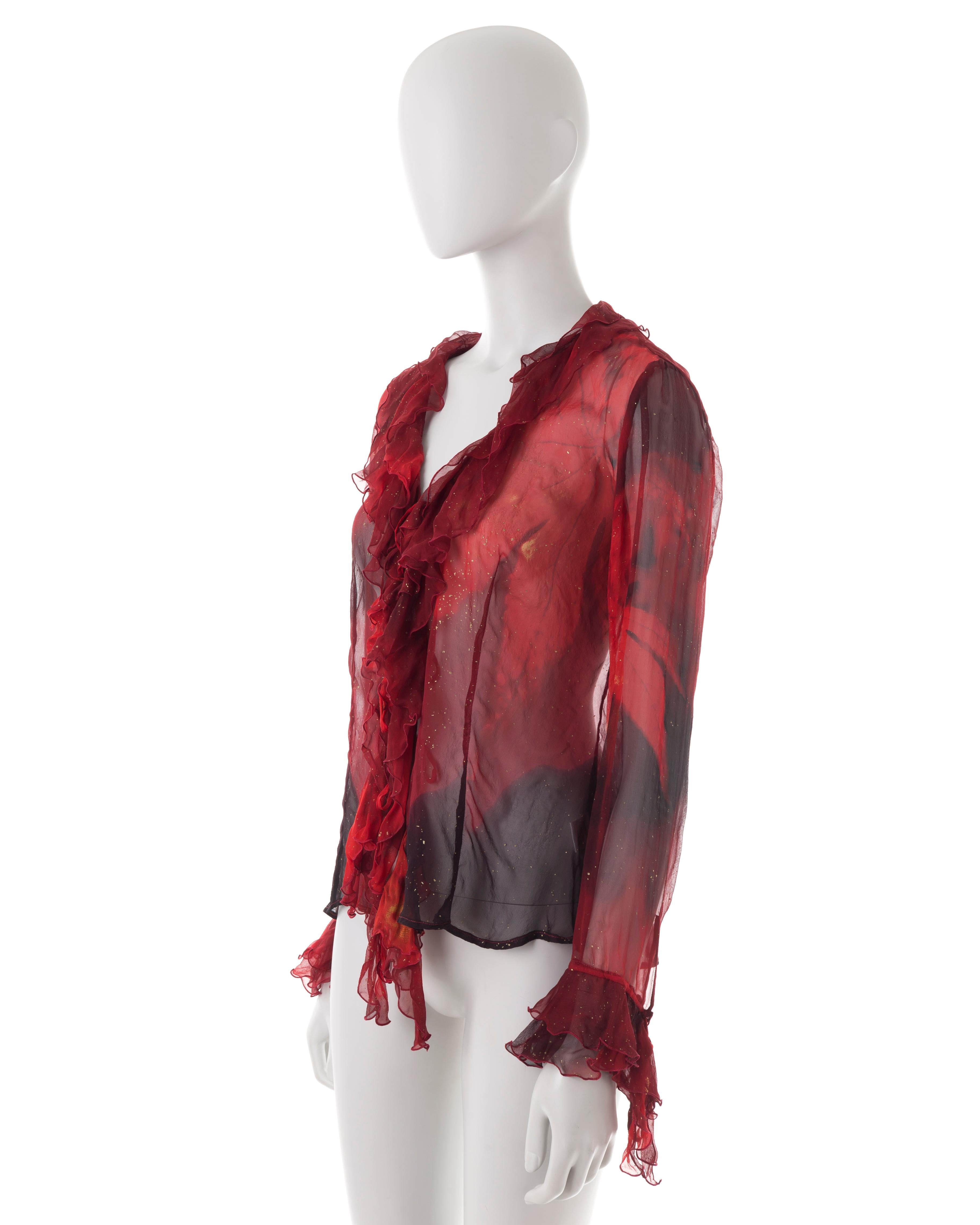 - Silk chiffon blouse
- Front and cuff ruffles
- Red and black glitter leaf print
- Triple front ties fastening
