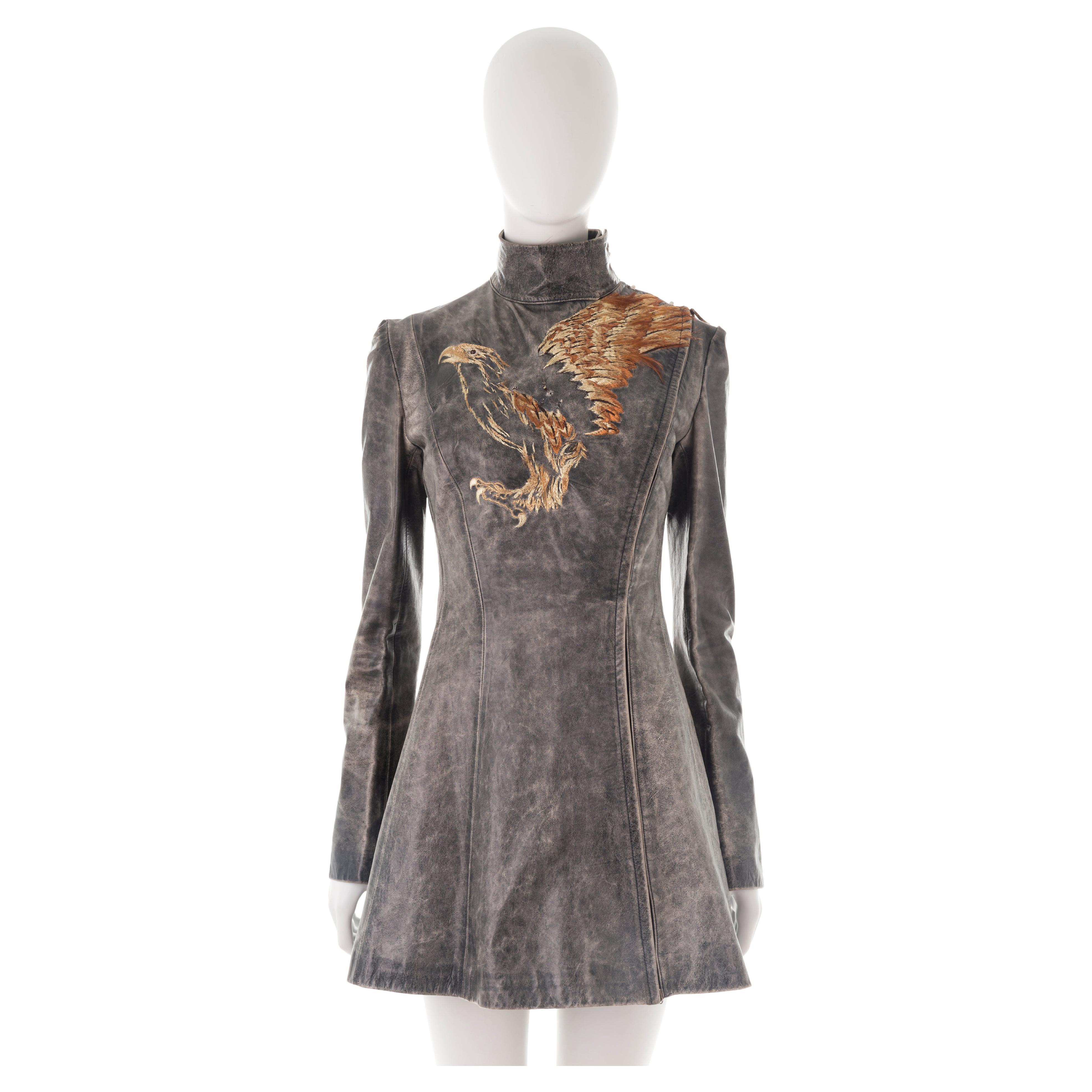 - Roberto Cavalli long sleeve mini dress
- Sold by Gold Palms Vintage
- Fall/Winter 2001
- Embroidered Phoenix motif with real feathers
- Brown soft distressed leather 
- Asymmetrical side zipper with collar hook fastenings
- Body-hugging fit
- Size