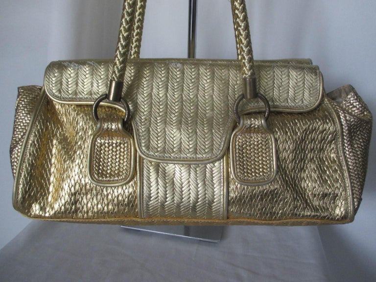 Vintage Exclusive Just Cavalli Golden Baquette bag  

We offer more exclusive vintage items, view our frontstore.

Details:
4 closing magnetic press buttons
1 zipper pocket inside
2 woven handles
Material; blend leather/cotton
Pre owned condition: