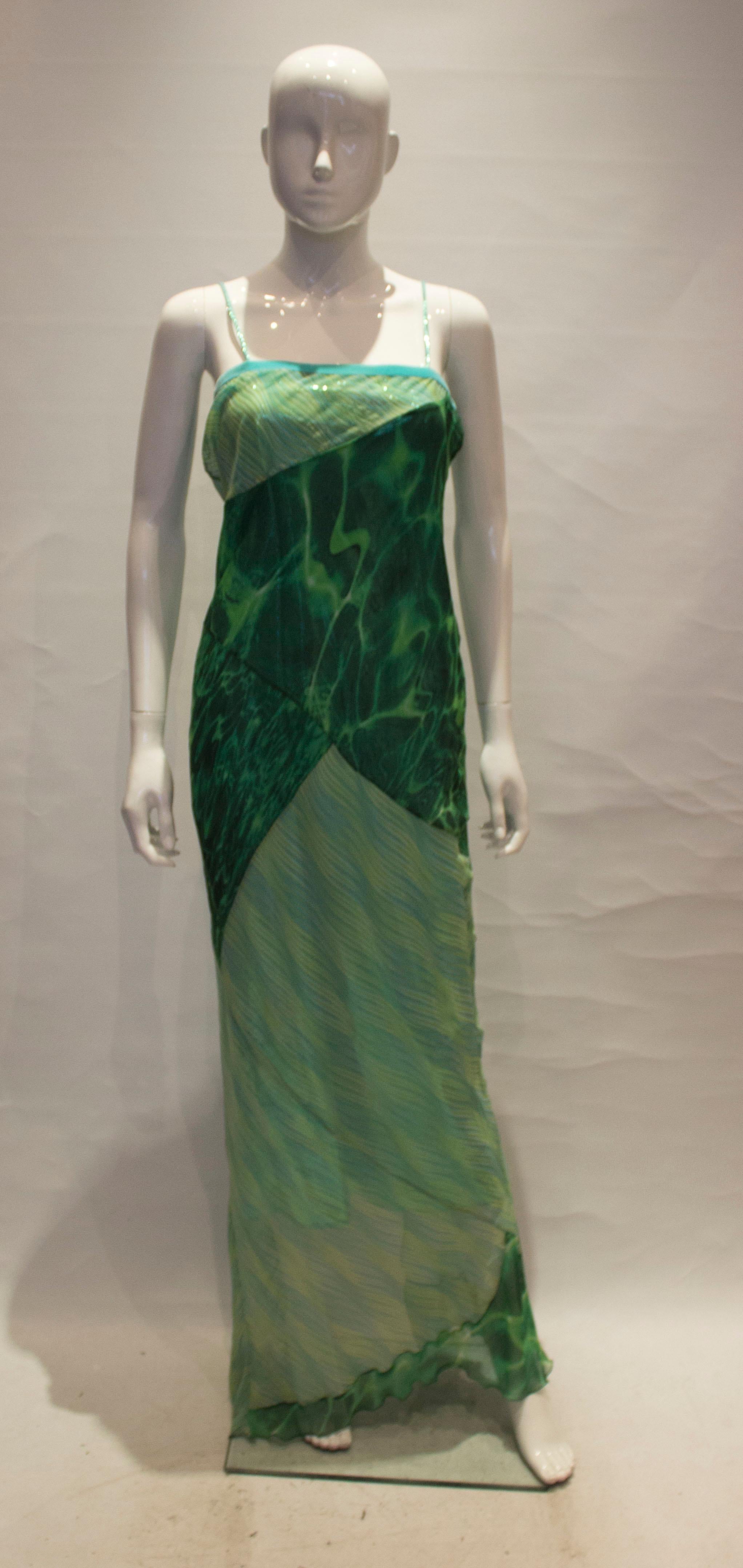 A colourful evening gown from Roberto Cavallli. The dress is in two parts, the inner tube shift is in a wonderful  green with velvet trim and spagetti straps. The over / outer dress is in a mix of two prints , strapless with a velvet trim.