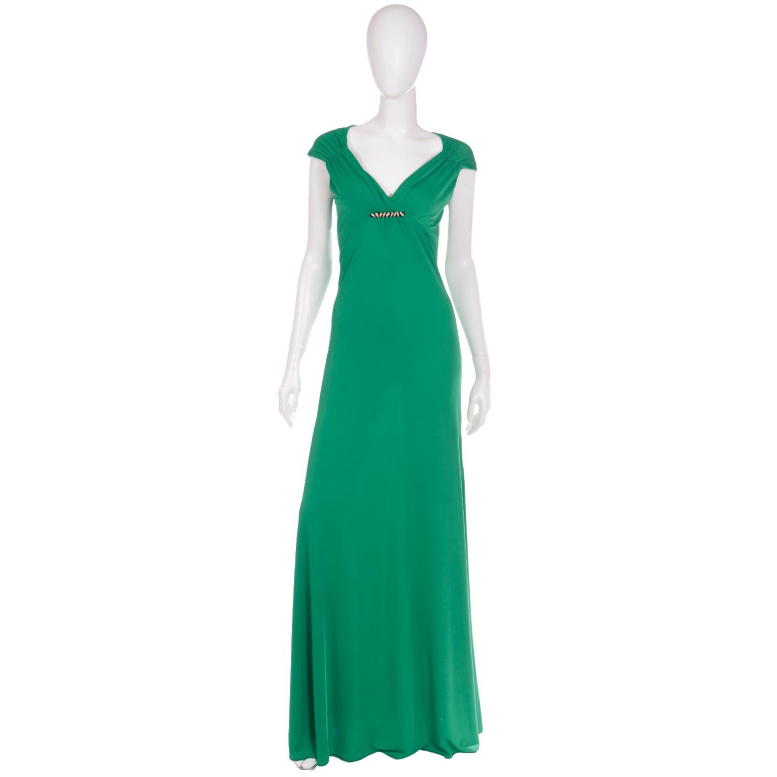 This gorgeous green jersey Roberto Cavalli full length evening dress is deadstock with its original tags and holographic authenticity sticker attached. This lovely dress has an empire waist with gathered shoulders and a low V gathered front,