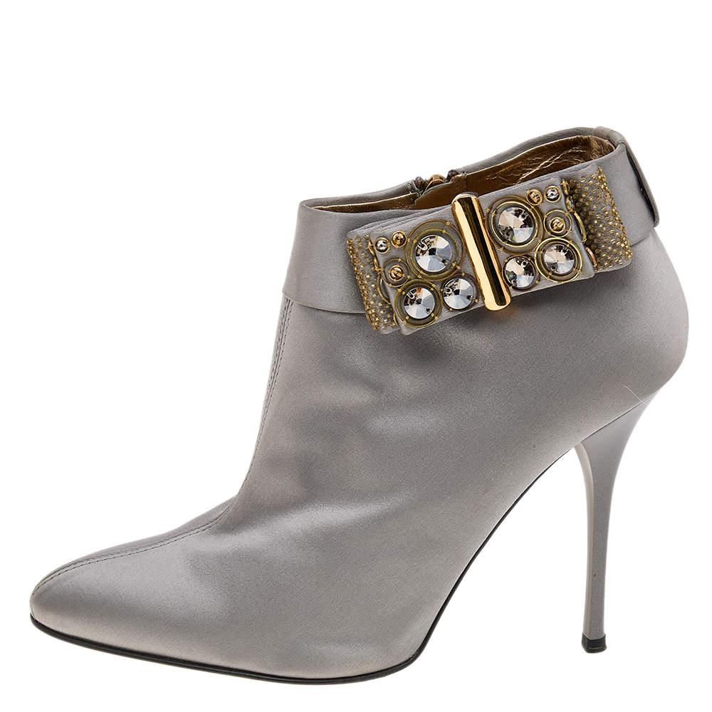 Keep your style sparkling and stunning with these boots from the House of Roberto Cavalli. They are made from grey satin on the exterior with a delicate embellished-bow accent highlighting their appearance. They flaunt pointed toes, slim heels, and