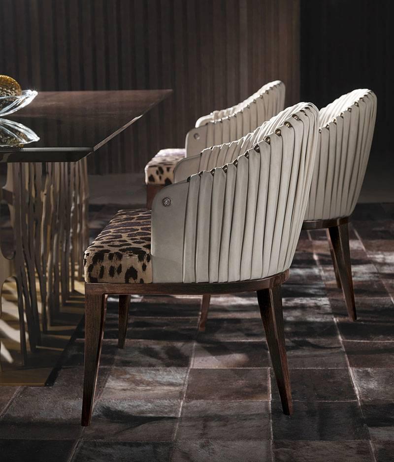Armchair with poplar wood and foam structure. Upholstery in fabric or leather from the collection. Interior capitonné back with metal plates available in all the finishes from the collection. Snake arms and feet in melted brass available only in