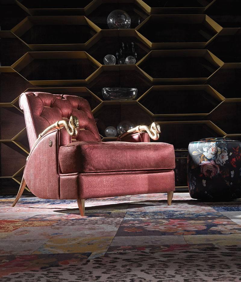 Armchair with poplar wood and foam structure. Red leather upholstery with interior capitonnè back with gold metal plates. Snake arms and feet in melted brass gold finishes.
