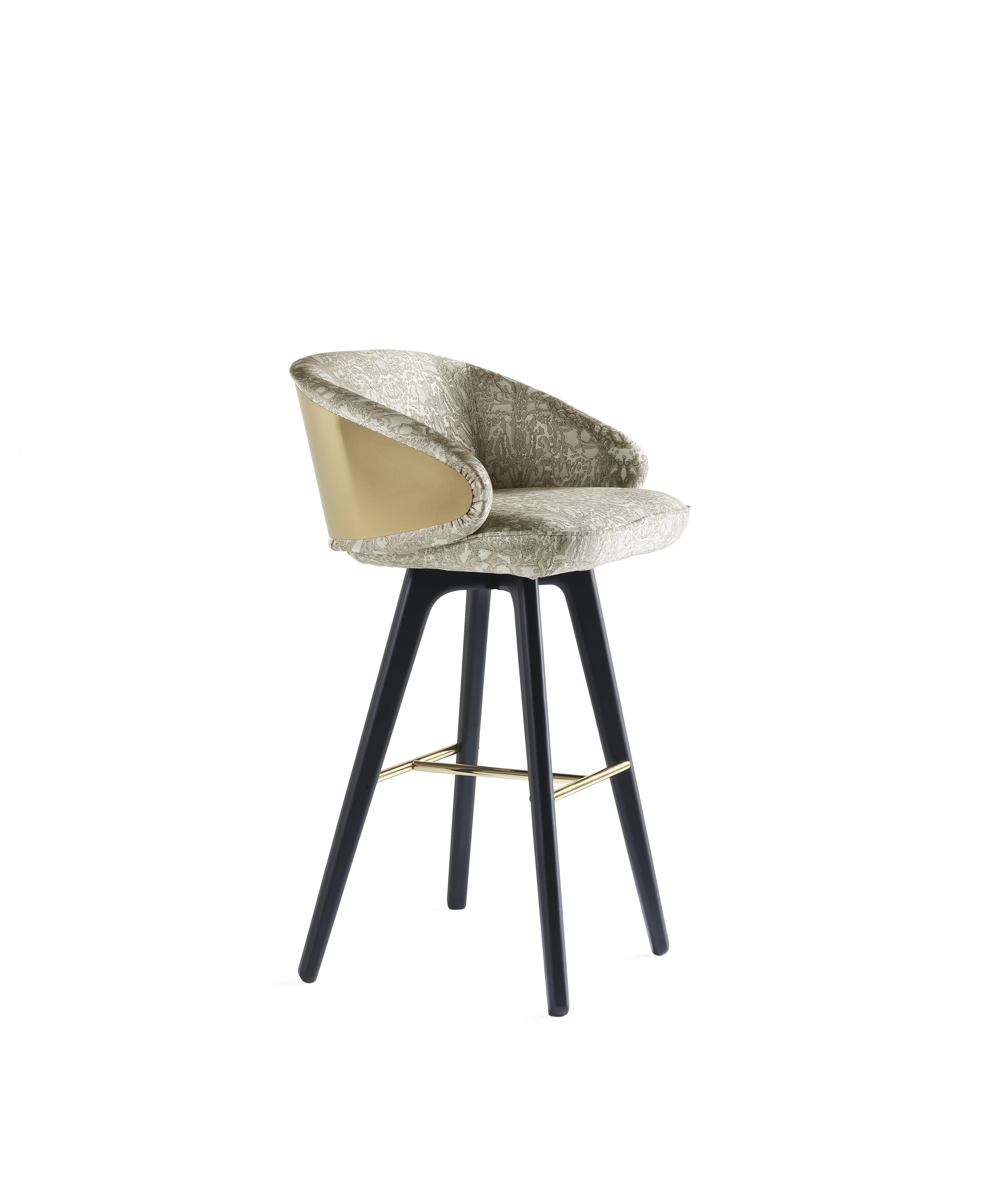 Key West Bar stool with structure in multi-layer wood and foam. Upholstery in fabric cat. A Jacquard Deni Col. B1. Wooden legs in black matt lacquered finishing with footrest in gold finishing. Metal back in gold finishing.