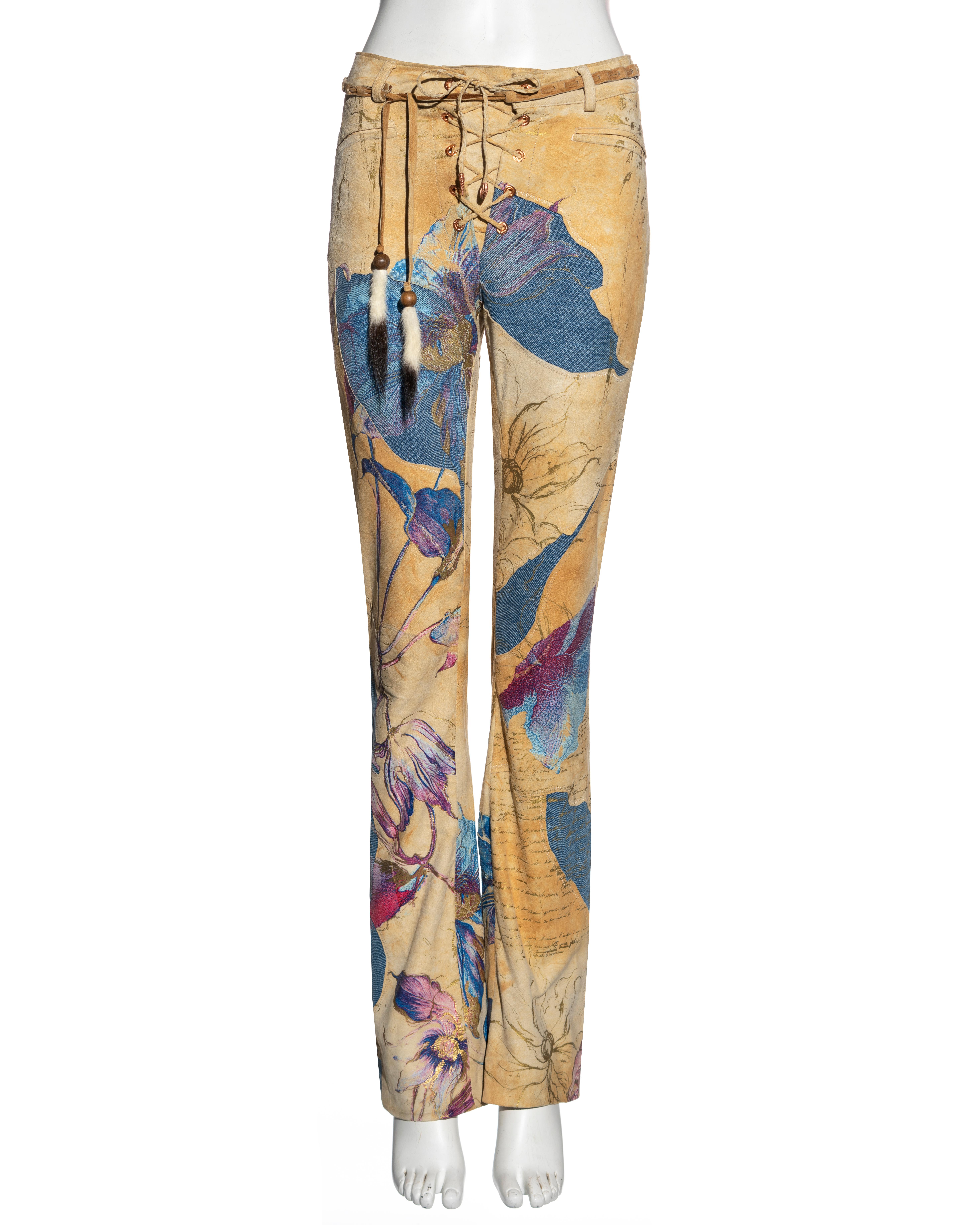 ▪ Roberto Cavalli pants 
▪ Sold by One of a Kind Archive
▪ Constructed from a patchwork of tan suede and blue denim
▪ Pink and purple floral print with gold foil overlay 
▪ Straight leg 
▪ Lace up and belt fastenings with mink fur
▪ Size: Small
▪