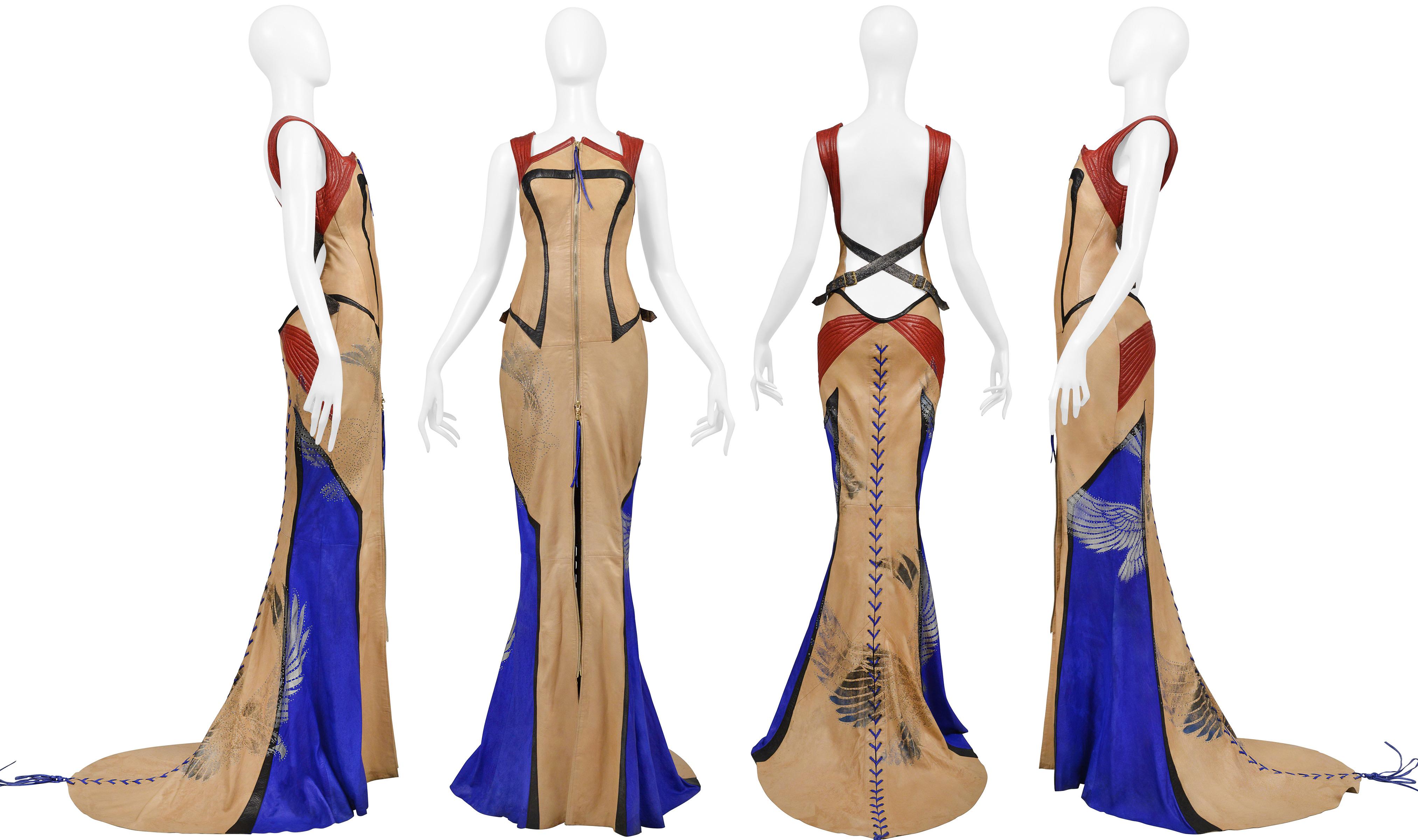 Resurrection Vintage is thrilled to showcase an exquisite vintage evening gown from Roberto Cavalli's 2003 collection. The gown features stunning red leather quilted straps and hip details, adorned with hand-painted eagles and symbols. The black