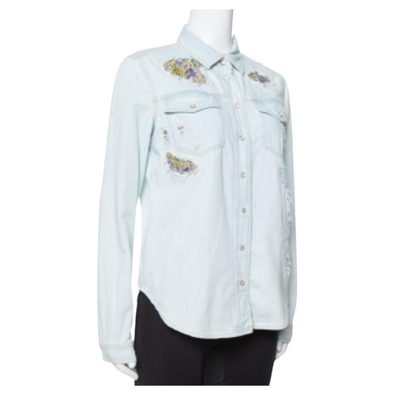 Beautifully made from denim cotton, this light blue Roberto Cavalli shirt is designed with front buttons, long sleeves, and a distressed style enhanced with colorful patches. The comfortable creation will surely add a luxe touch to your wardrobe.