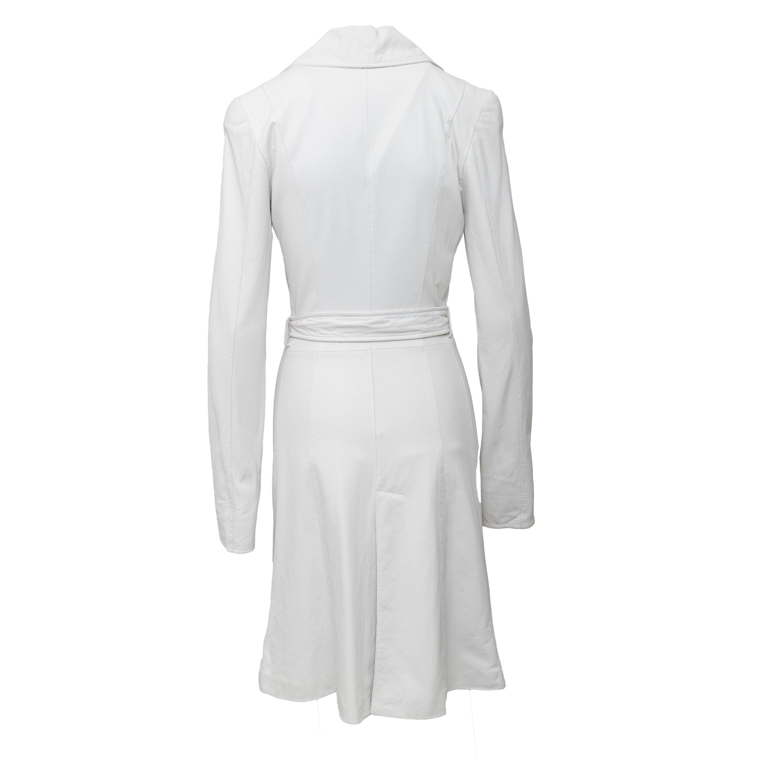 Discover a vintage treasure with the Roberto Cavalli Long Leather Jacket. Crafted in soft Nappa leather, this stunning white jacket features a classic trench coat style, complete with a waist belt, front pockets, and mother of pearl buttons. Unlined