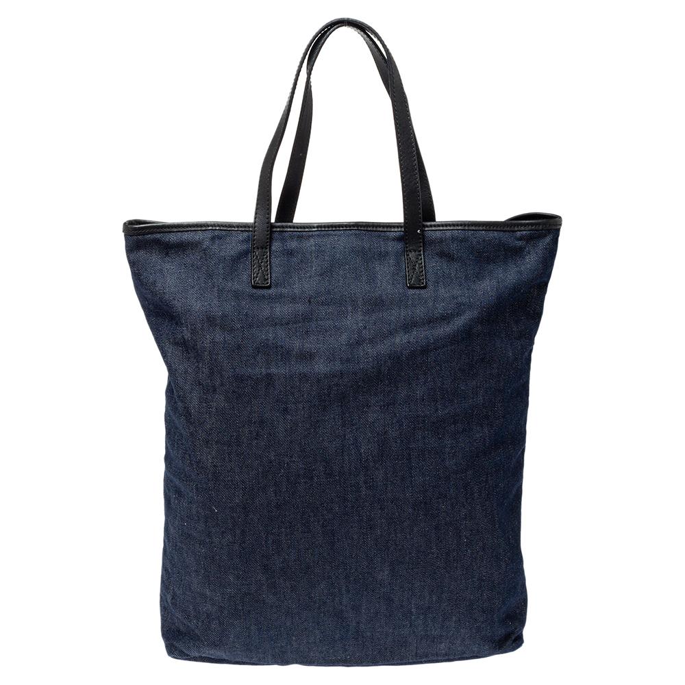 This stylish Roberto Cavalli tote is perfect for casual days. It has been crafted from denim and comes in a lovely shade of navy blue. It has dual handles, studded logo detailing in the front and a spacious canvas-lined interior. Grab it