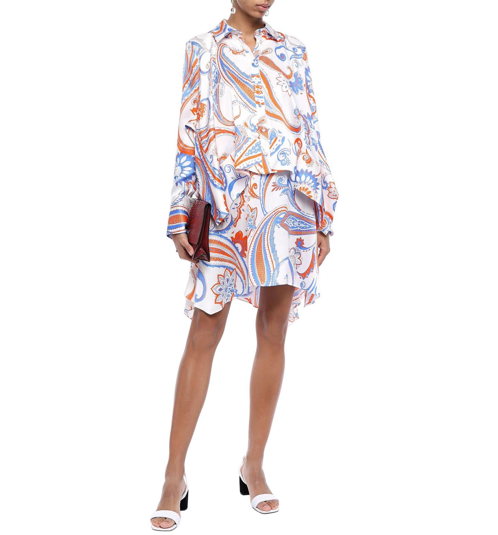This Roberto Cavalli silk mini shirt-dress features a vibrant orange and blue paisley print, an asymmetric layered silhouette, side slip pocket, and front button fastenings. Its light and silky material makes it a perfect dress for any occasion in