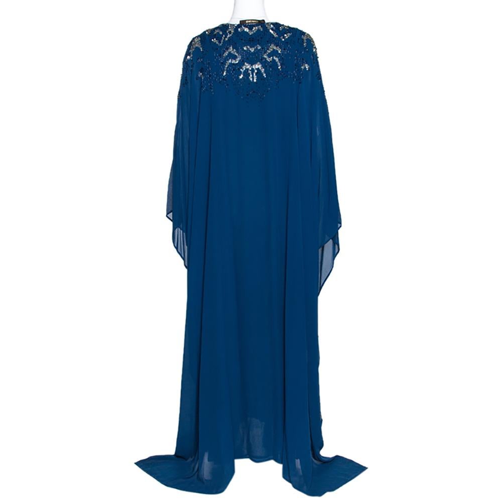 Perfect for special occasions and evenings, this kaftan dress by Roberto Cavalli is absolutely stunning. It is crafted from 100% silk and comes in a lovely shade of peacock blue. It is embellished with sequins & beads that add a touch of glamour. It