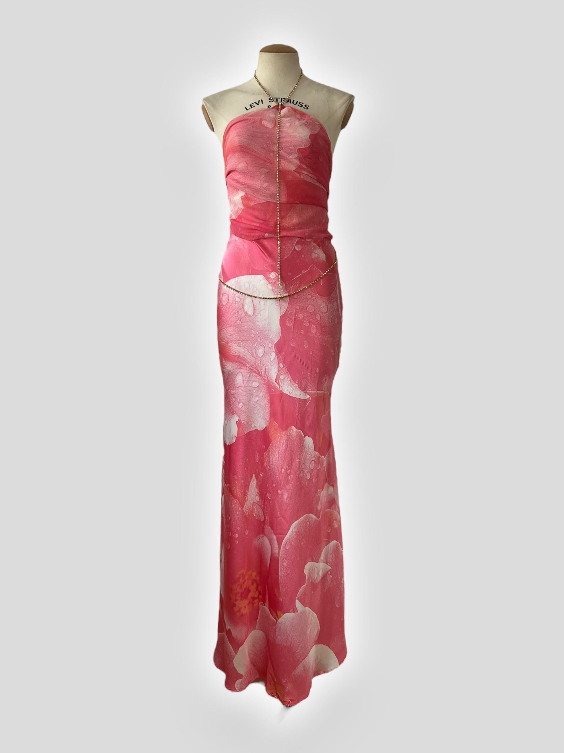 This stunning silk gown features a striking abstract floral pattern in shades of coral pink and white, reminiscent of the version Alek Wek wore on Roberto Cavalli's Spring 2000 runway. The design includes a flowing maxi-length skirt with a slight