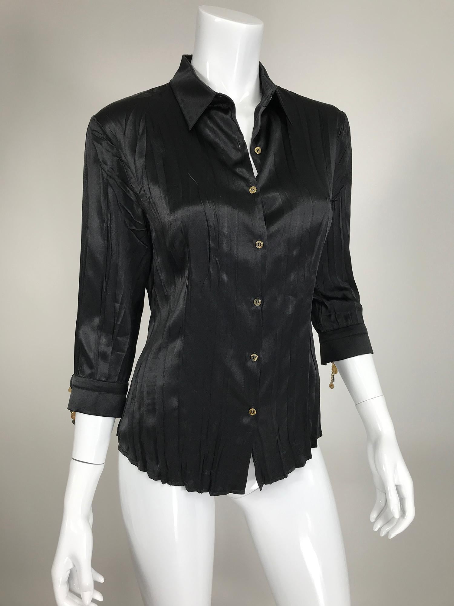Roberto Cavalli pleated black silk satin jewel sleeve blouse. Relaxed pleated blouse with 3/4 length sleeves that have banded cuffs and gold & silver coin & chain closures. The blouse closes at the front with gold logo buttons. Marked size medium.