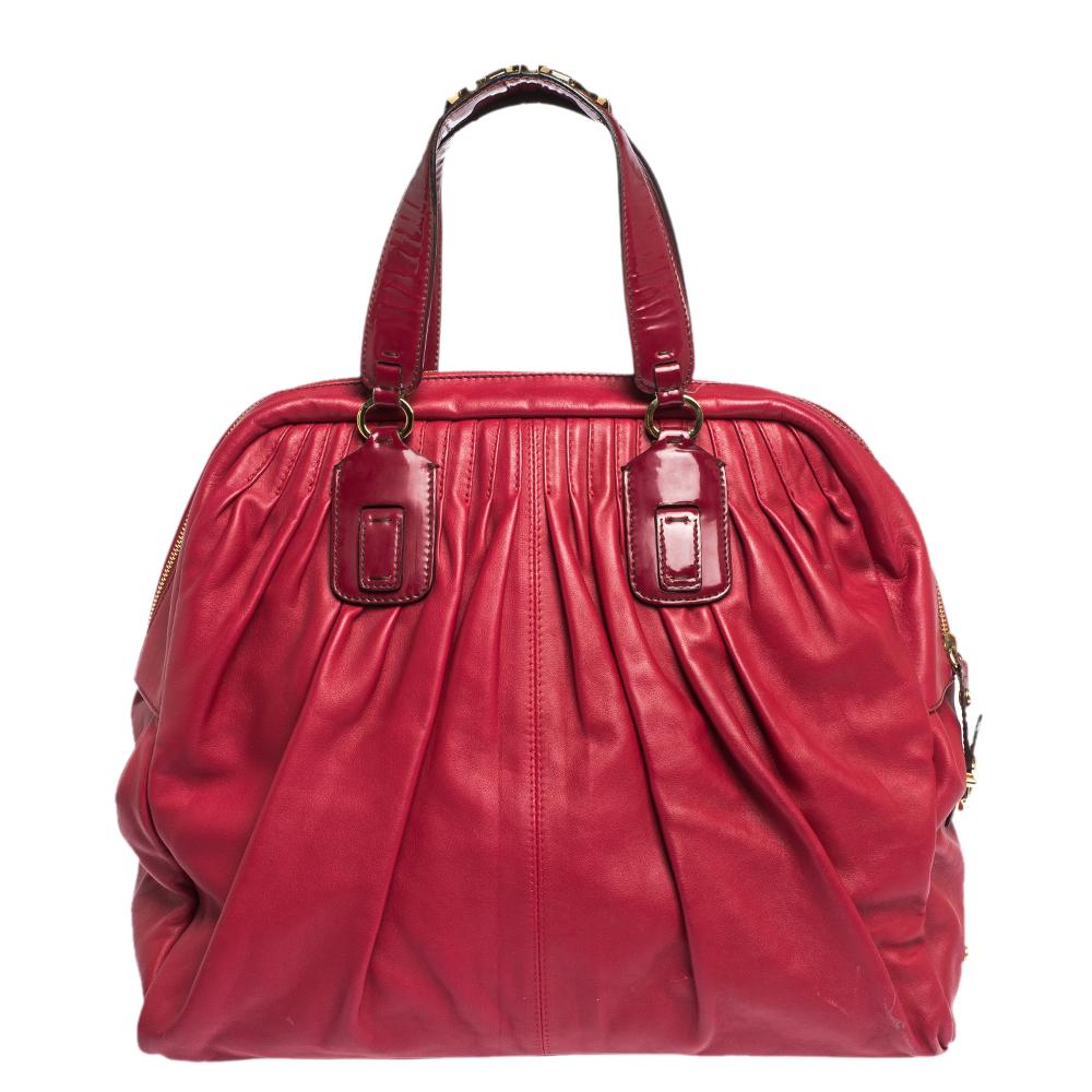 This stunning satchel bag comes from the iconic house of Roberto Cavalli. It has a striking exterior that comes in a shade of red. It has been crafted from quality leather and features pleat detailing. It is styled with dual handles with chain