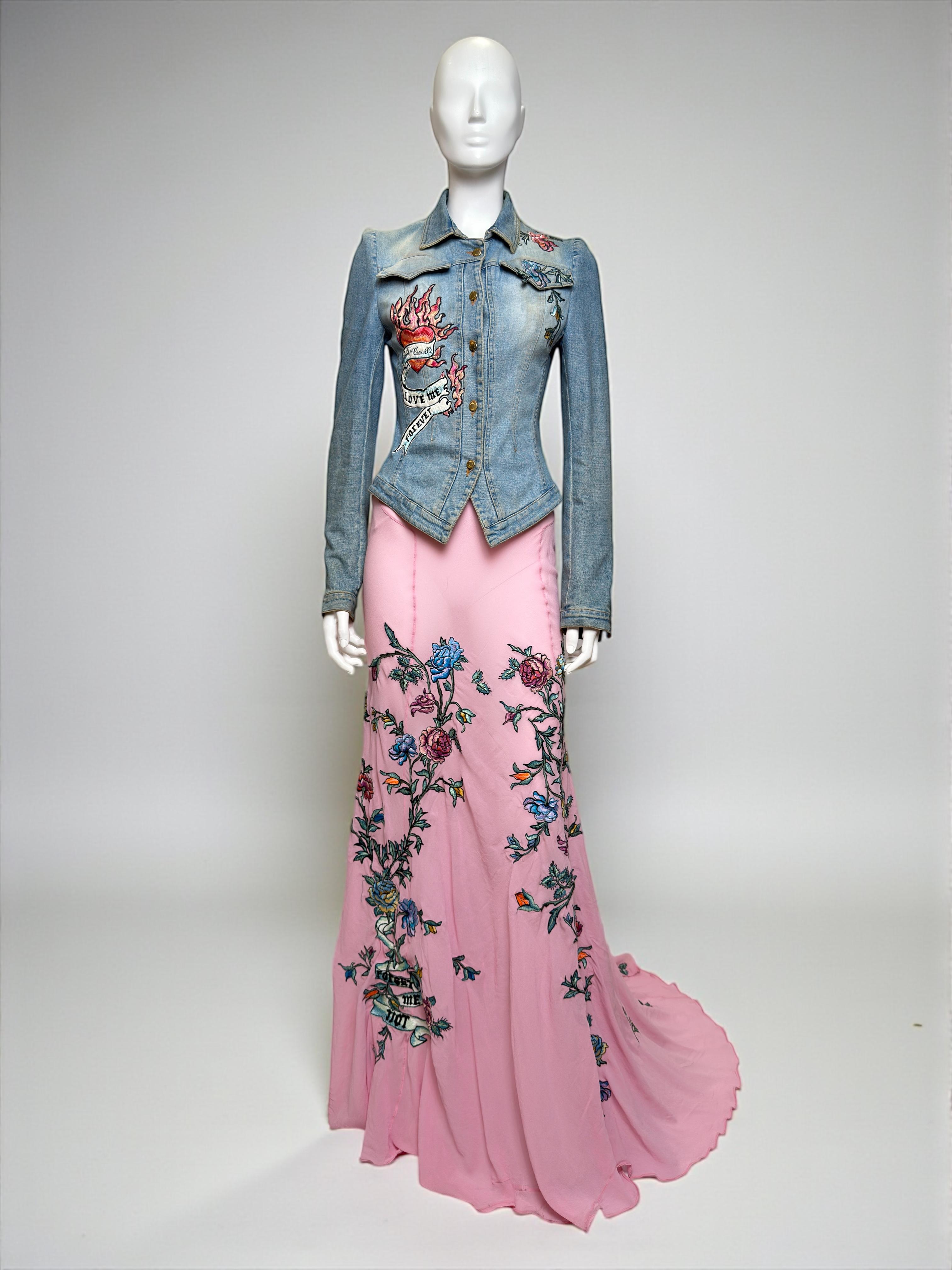 Roberto Cavalli Spring–Summer 2003 runway set consisting of a fitted denim jacket and a sheer mermaid-cut maxi skirt. The jacket is crafted in washed blue denim and embellished with the collection’s signature tattoo-style embroidered motifs. The