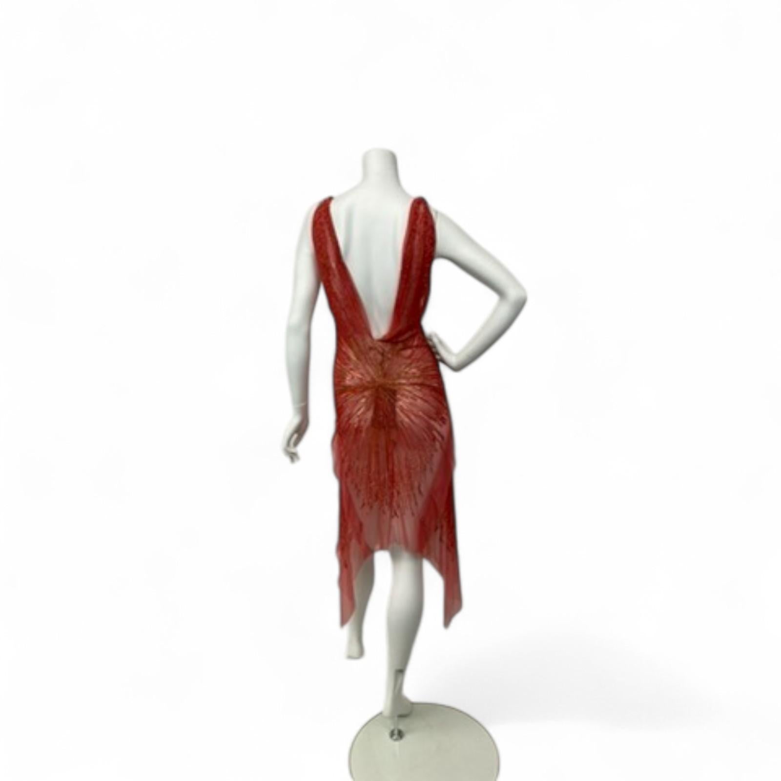 A striking piece from Roberto Cavalli’s Spring/Summer 2005 runway collection, this breathtaking gown captures the spirit of early 2000s glamour and Cavalli’s signature bold sensuality.

Crafted from layers of vibrant red tulle interwoven with