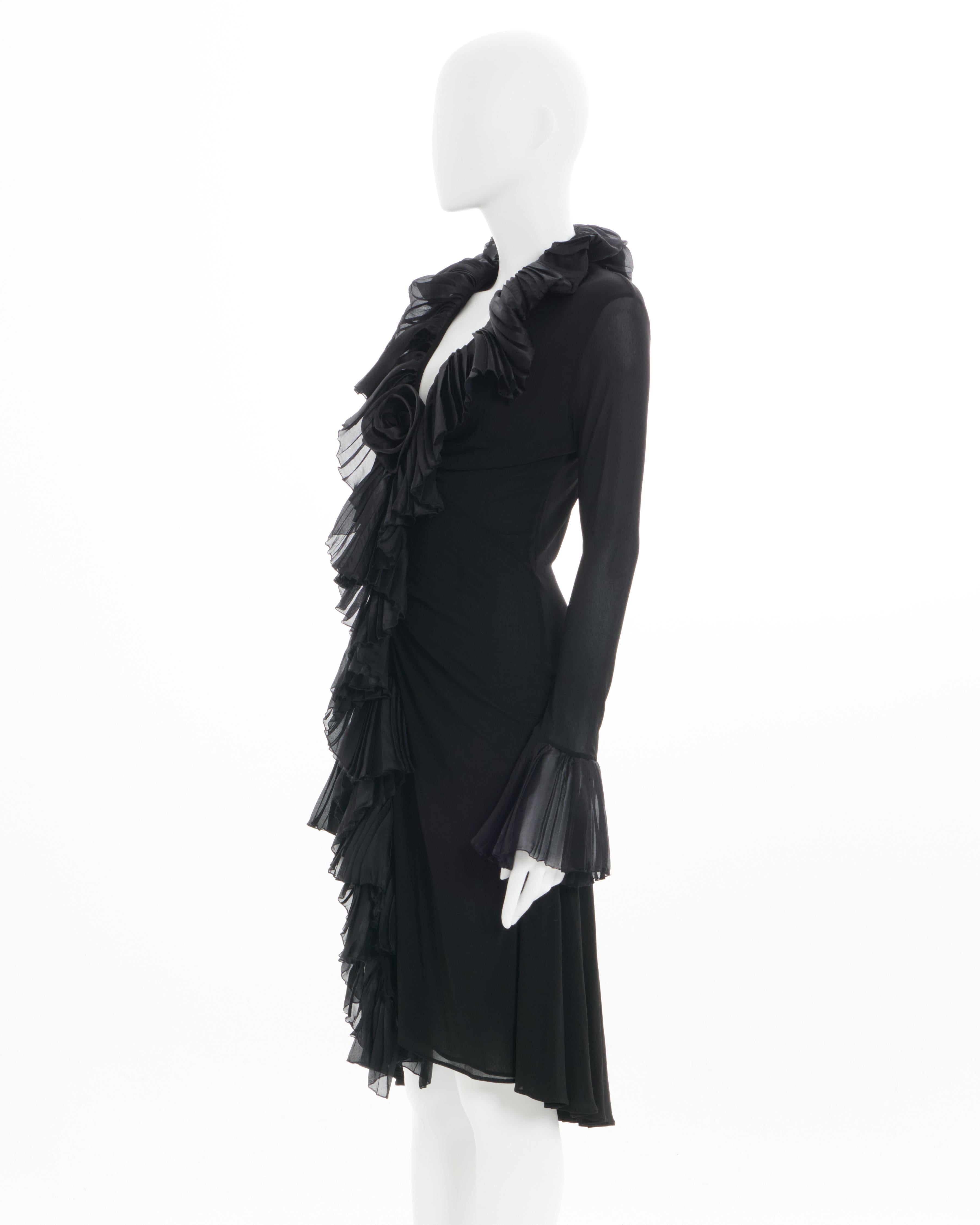 - Roberto Cavalli
- Sold by Skof.Archive
- Spring - Summer 2006 
- Black ruffle cocktail dress 
- Frontal hook-and-eye closure 
- V-neck
- Above knee-length 
- Fitted to the body 
- Size: Size: FR 40 - EN 44 - UK 12 - US 8 
- Fabric: Viscose & Silk