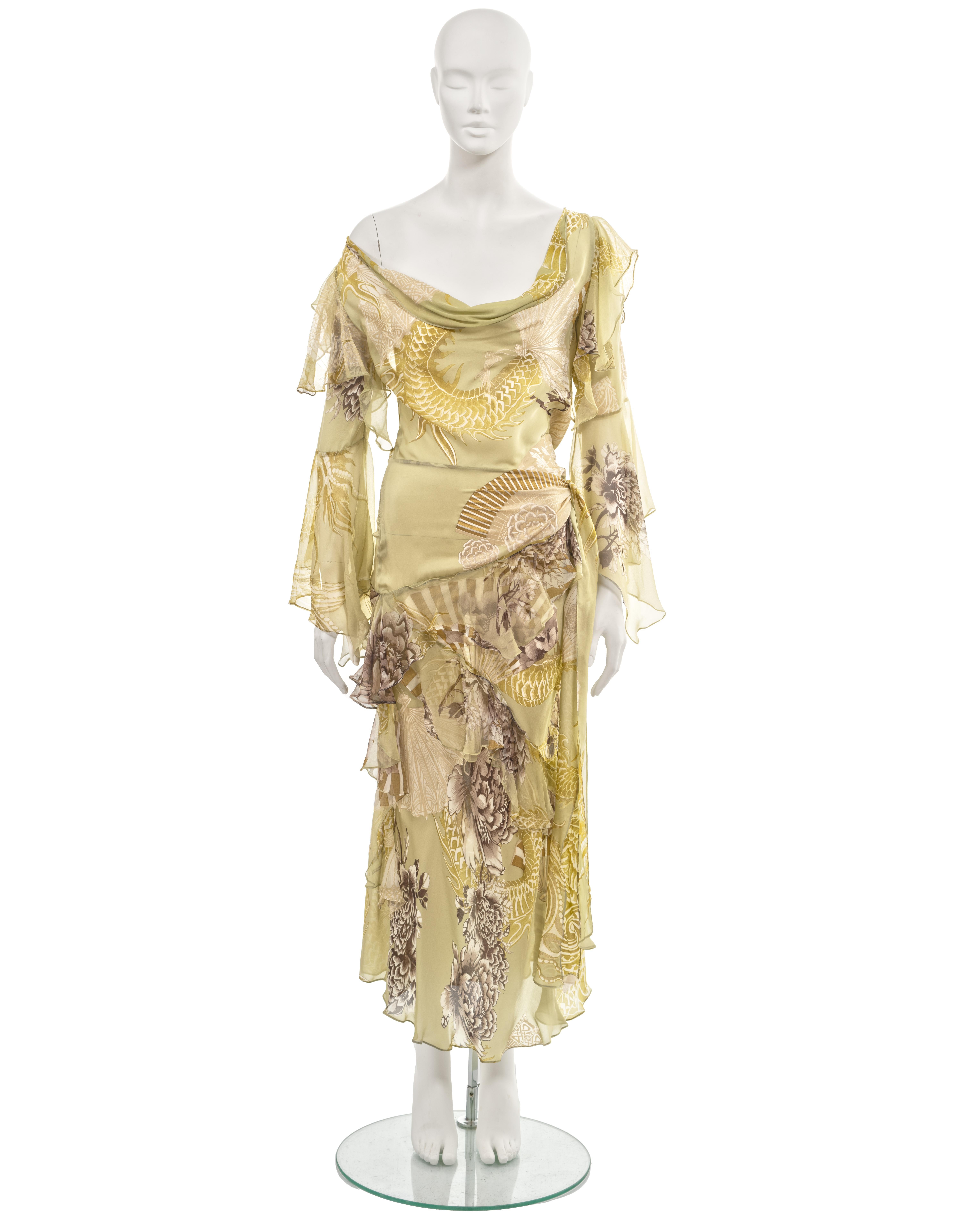 ▪ Roberto Cavalli evening dress
▪ Fall-Winter 2006
▪ Crafted from sage green silk chiffon adorned with a motif showcasing peony flowers, dragons, and fans in elegant shades of grey, cream, and gold
▪ Designed with a wide cowl neck that can be styled