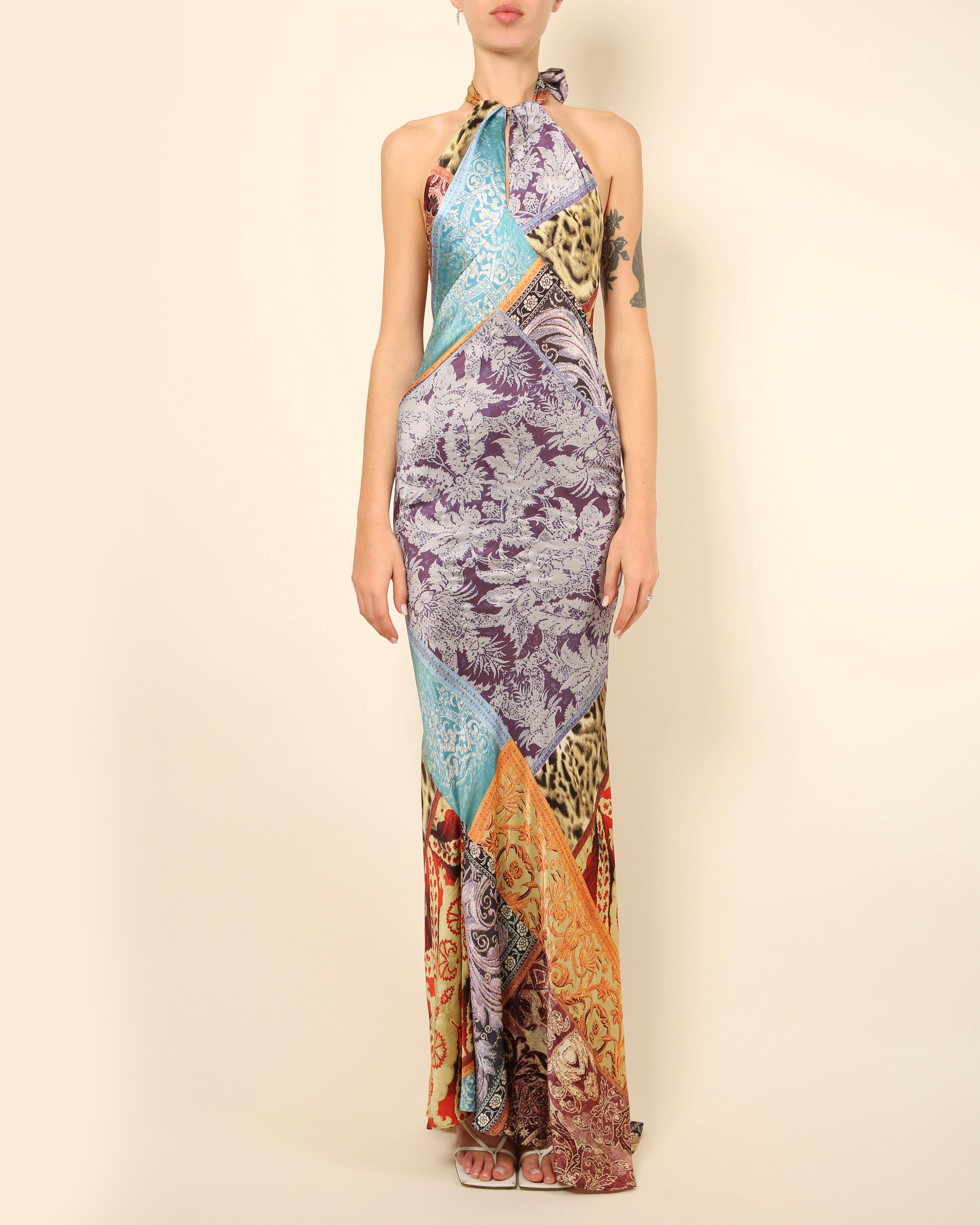 Roberto Cavalli floor length silk gown with a slight train
Halter neck - tying at the back of the neck with long silk ties
Low cut back
Multicoloured consisting of purple, lilac, orange, yellow, green, turquoise, blue, red, brown and black with gold