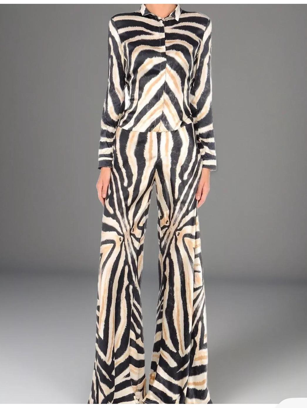 Combinaison de Roberto Cavalli en 100% soie avec un imprimé zébré audacieux.  Cette pièce offre tout ce que l'on est en droit d'attendre de l'époque. Il est taillé dans une soie fluide et arbore l'un des imprimés zébrés emblématiques de la maison,