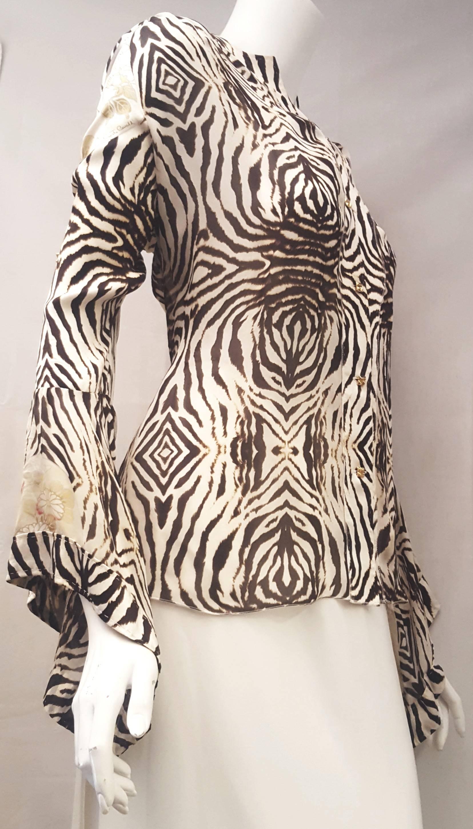 Roberto Cavalli's effortlessly draping top takes its cues from loose poncho fitting styles. It is lightweight and flowy, and this style comes with Zebra print with flower medallions throughout. The piece de resistance are the gold tone square