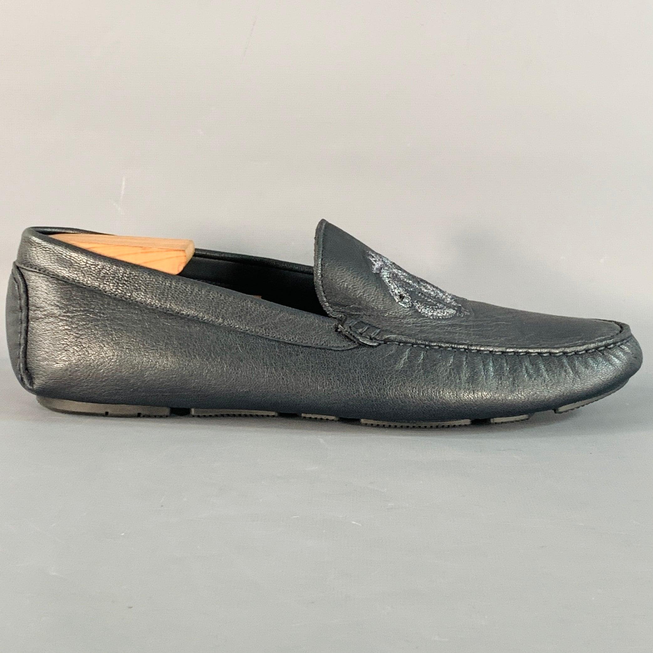 Mocassins ROBERTO CAVALLI en cuir marine avec logo brodé en argent métallique, style chauffeur et fermeture à glissière. Les embauchoirs ne sont pas inclus. Fabriqué en Italie. Excellent état.  

Marqué :   7700 44.5Semelle d'usure : 12 pouces  x