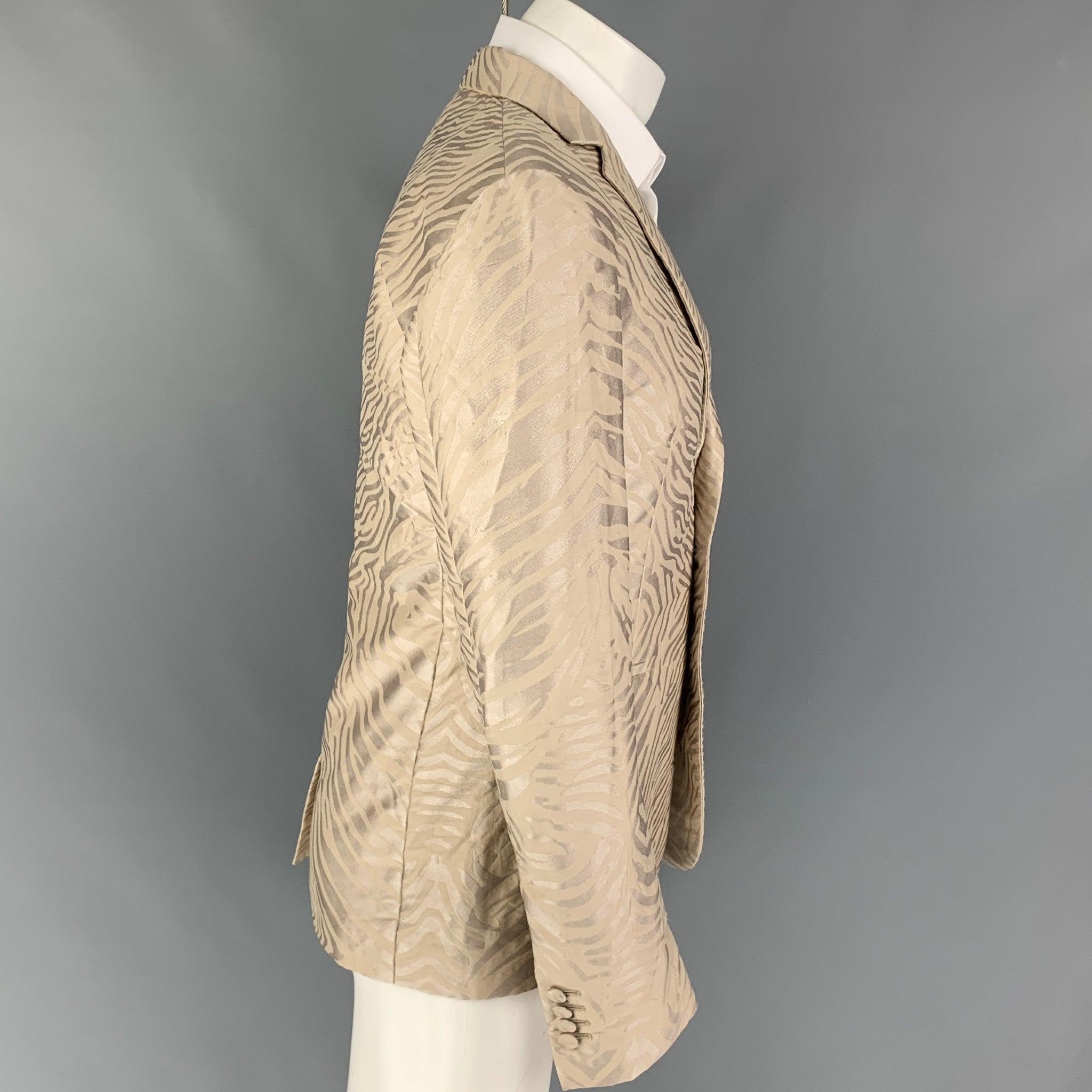 ROBERTO CAVALLI
sport coat comes in a tan jacquard polyester blend with a full liner featuring a notch lapel, slit pockets, single back vent, and a double button closure. Made in Italy. New With Tags.  

Marked:   48 

Measurements: 
 
Shoulder: