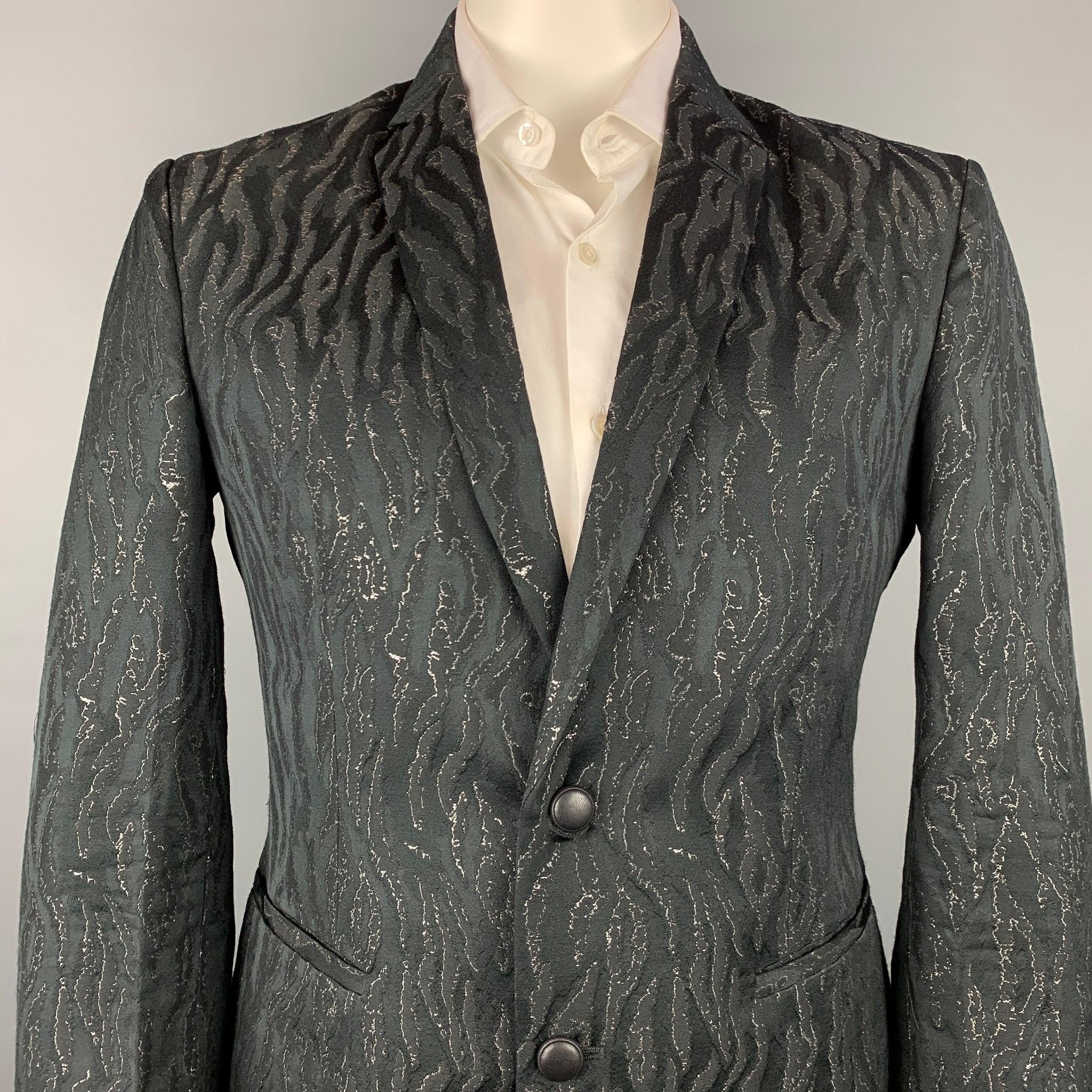 ROBERTO CAVALLI
sport coat comes in a black & gold jacquard wool blend with a full liner featuring a peak lapel, slit pockets, and a two button closure. Made in Italy. Very Good Pre-Owned Condition.  

Marked:   IT 54 

Measurements: 
 
Shoulder: 19