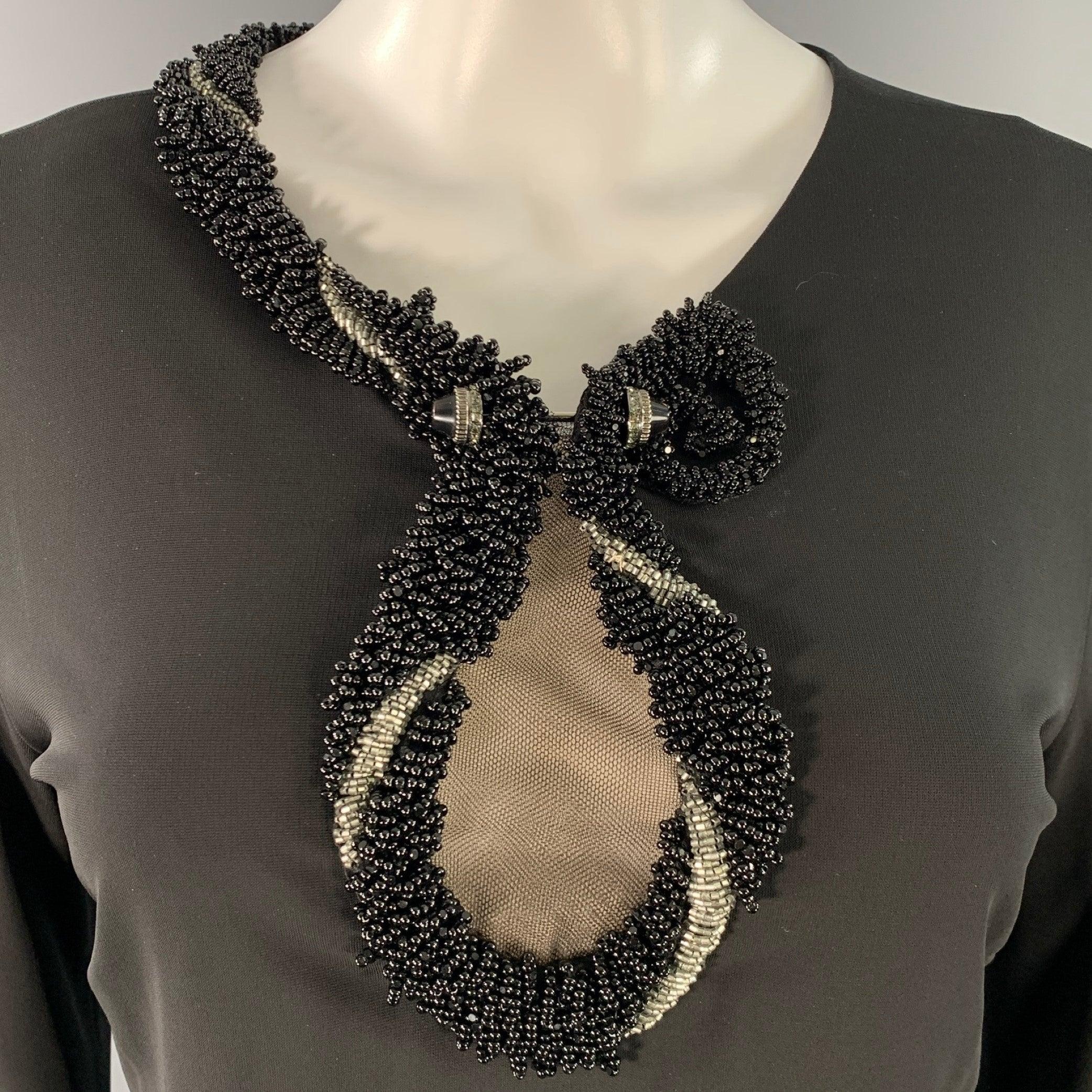 ROBERTO CAVALLI robe de cocktail
en jersey extensible de viscose noire, avec une encolure ornée de perles noires et argentées et de mailles en trou de serrure, des manches longues et une fermeture à glissière dans le dos. 

Marqué :   IT 44