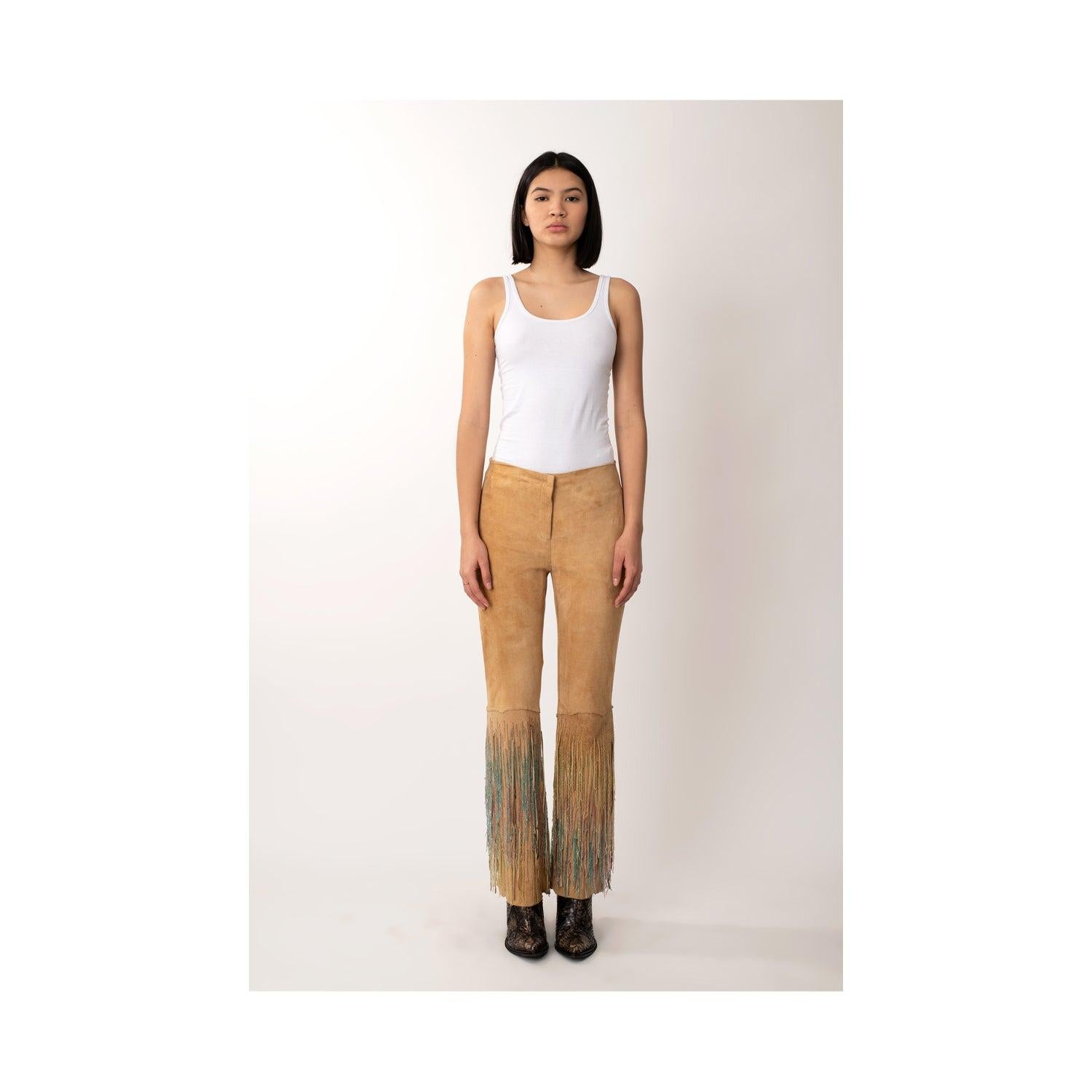 These Roberto Cavalli beige suede pants are adorned with multicolor crystals, adding a touch of luxury to the classic design. The zip fastening ensures a secure fit, making these pants perfect for any occasion. 
 Remarks: There are minimal signs of