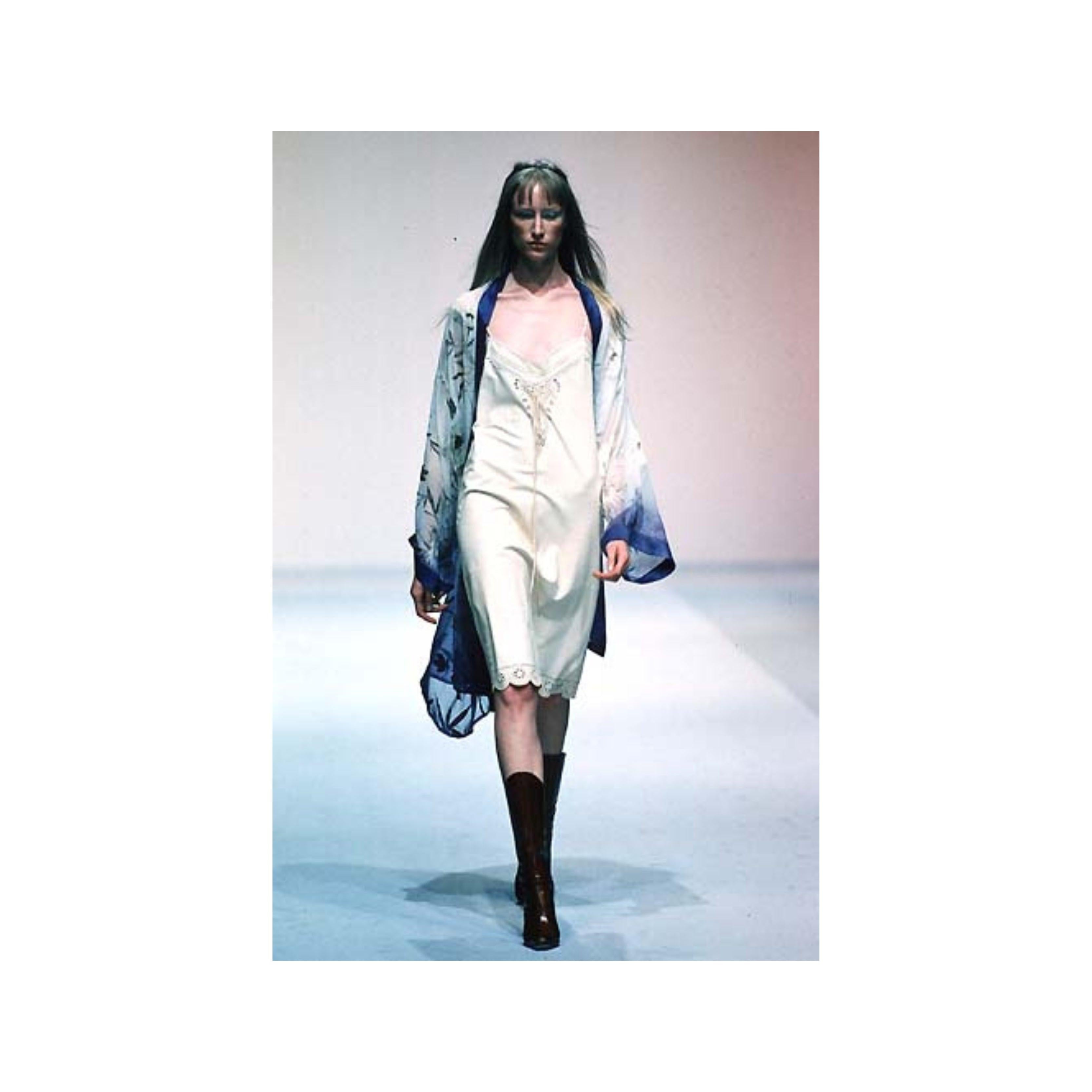 Effortlessly elevate your wardrobe with the Roberto Cavalli Tie-knot Kimono dress from the 90s. This loose-fitting open front dress features an intricate flower and leaf pattern, accented by a blue satin border. With a belt included, style this