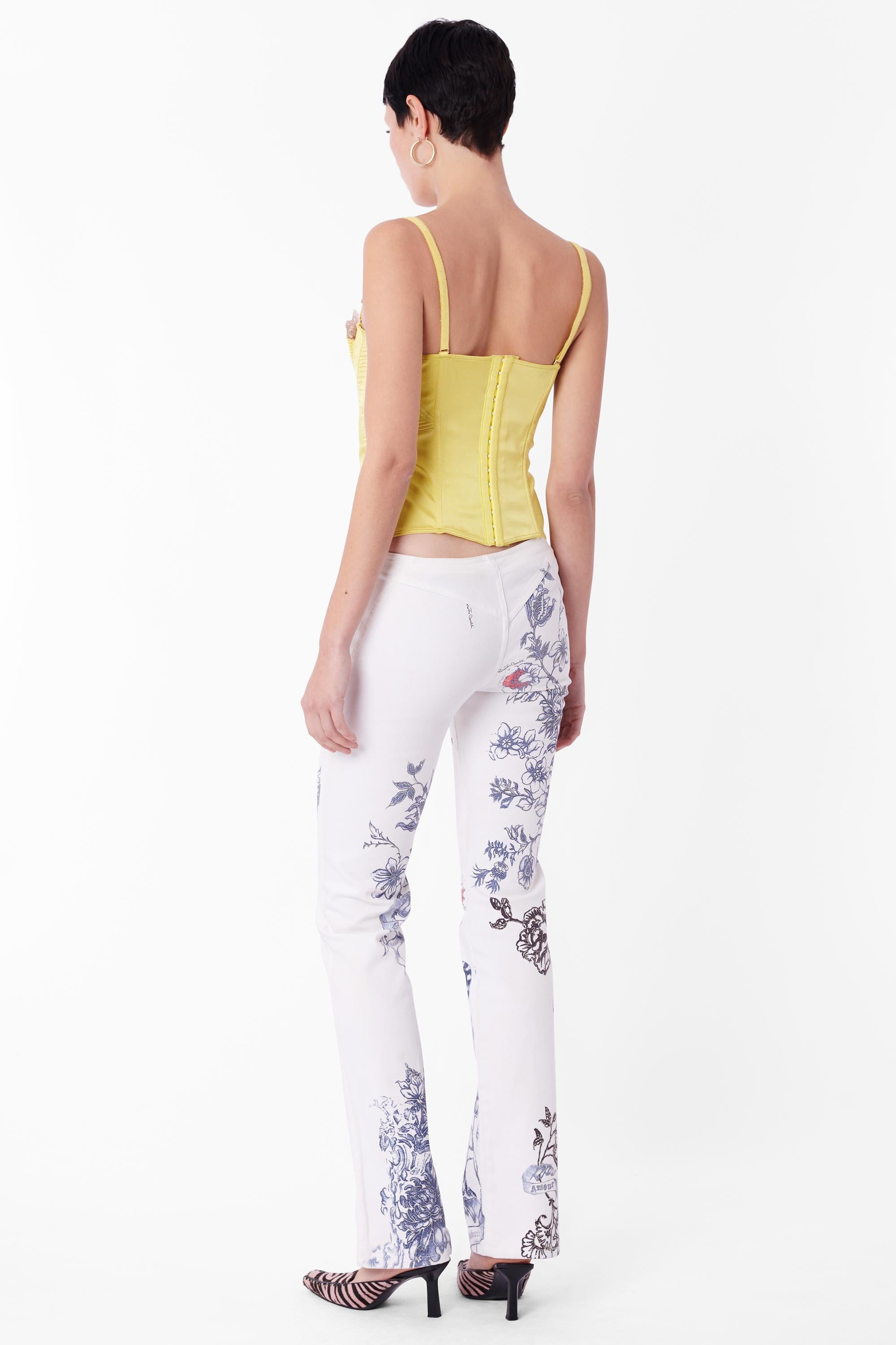 Vintage Roberto Cavalli Spring Summer 2003 white denim jeans. Features the iconic ‘Tattoo’ print, visible gold zip front closure with ‘C’ snake hardware, bootcut leg, yolk silhouette on the back. In excellent vintage condition. As seen on the